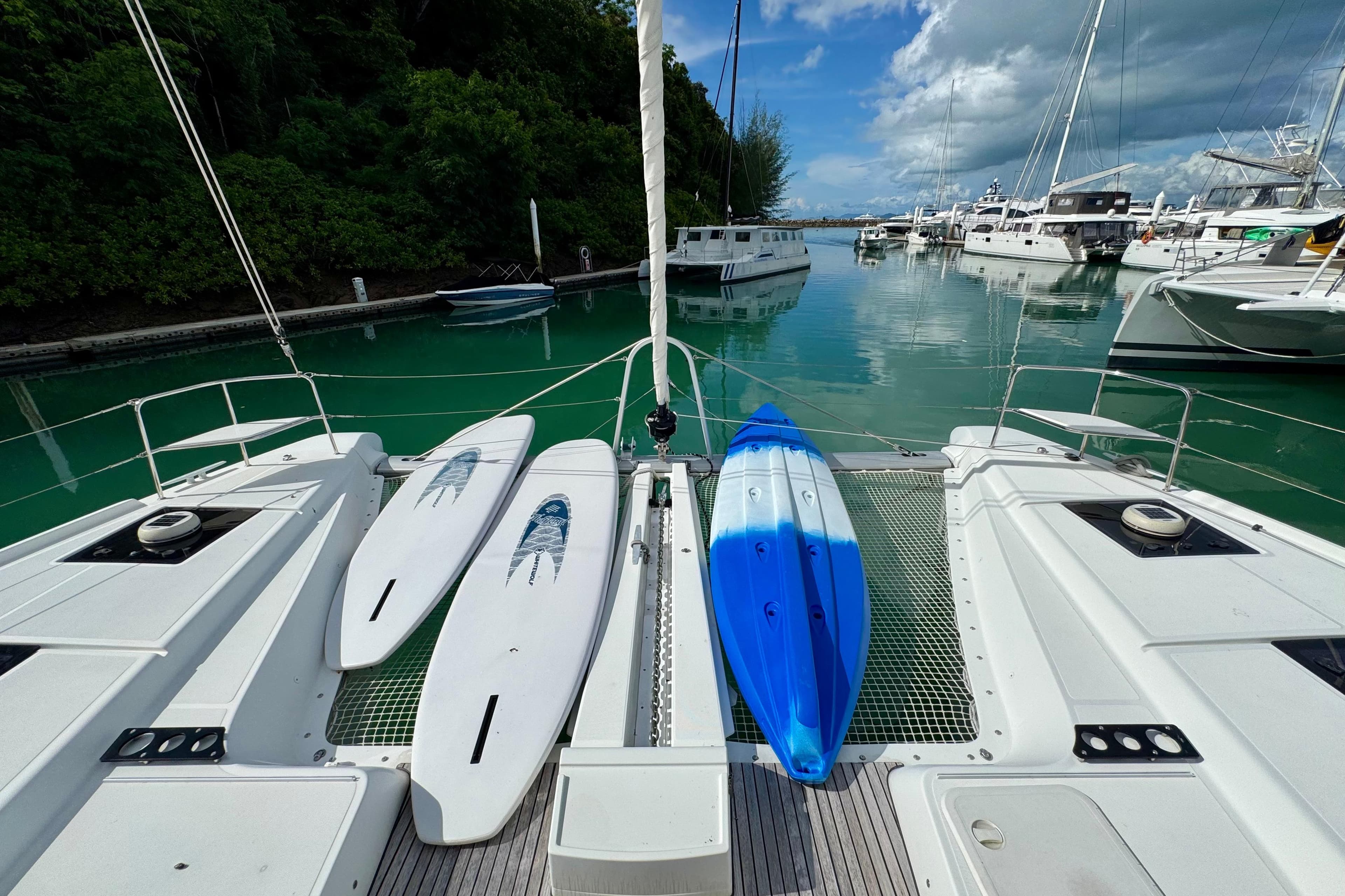 Lagoon 50 catamaran with paddleboards and kayak docked in a serene marina, 2020 model.