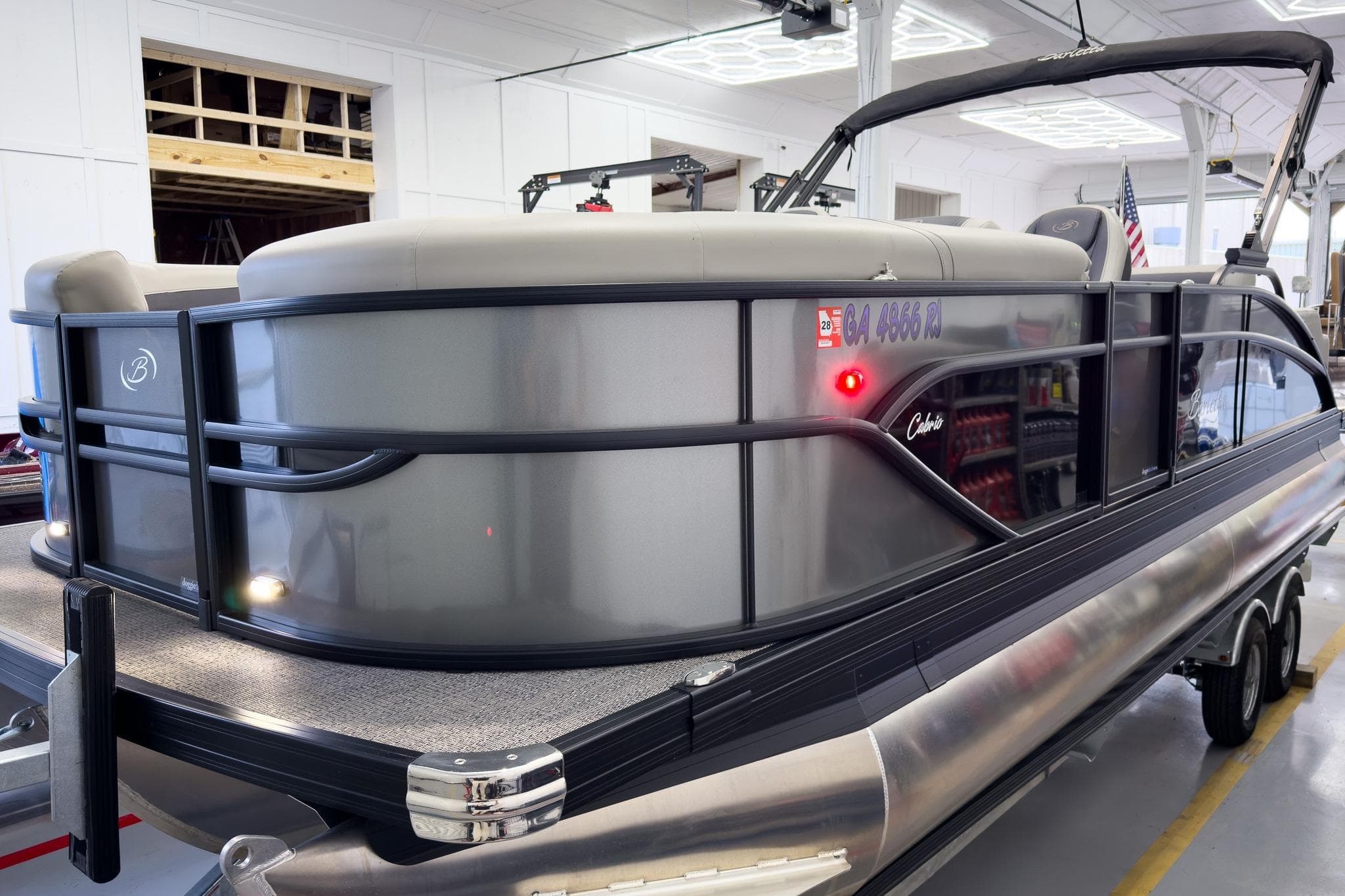 2025 Barletta Cabrio 22UC pontoon boat in a showroom, showcasing sleek design and modern features.