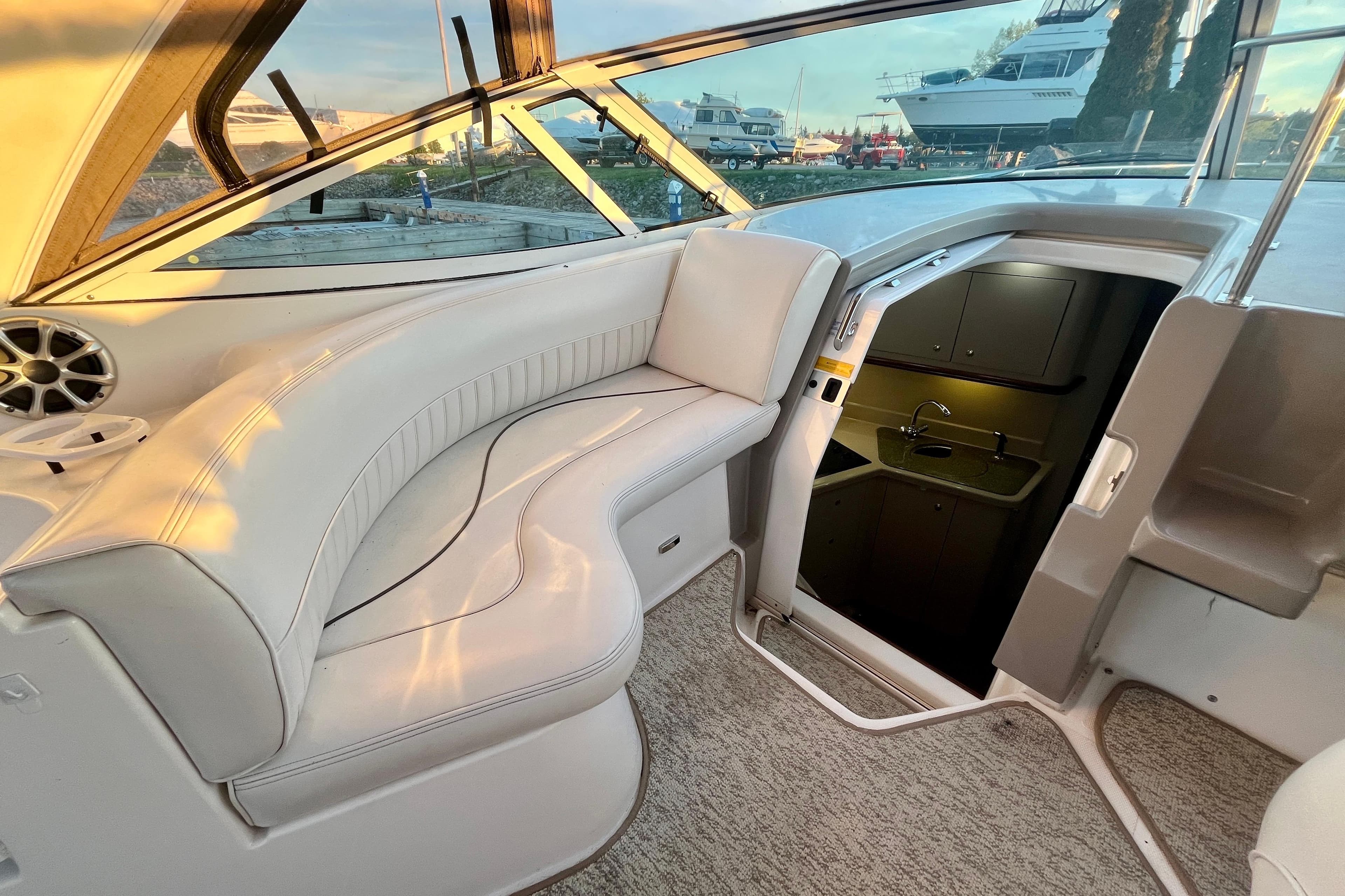 2001 Cruisers Yachts 3470 Express interior with white seating and cabin entrance.