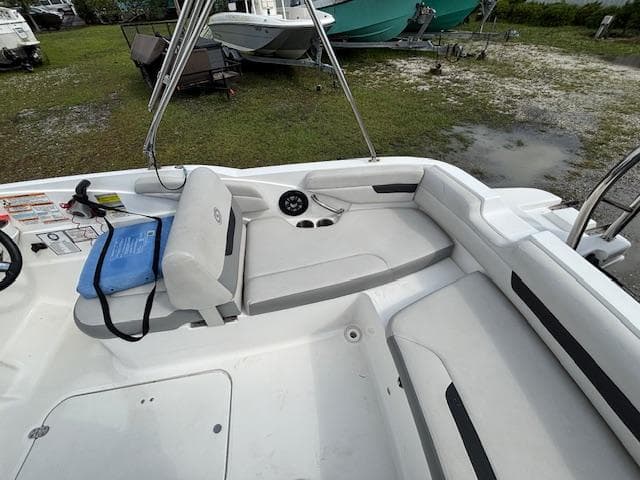 2022 Hurricane SunDeck Sport 185 OB boat interior with white seating and steering wheel.