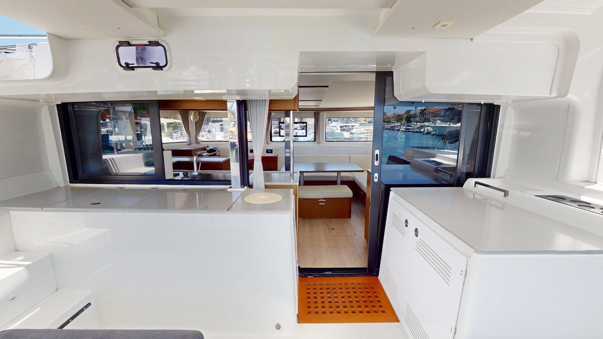 Interior of 2020 Lagoon 46 catamaran, featuring modern kitchen and dining area with marina view.