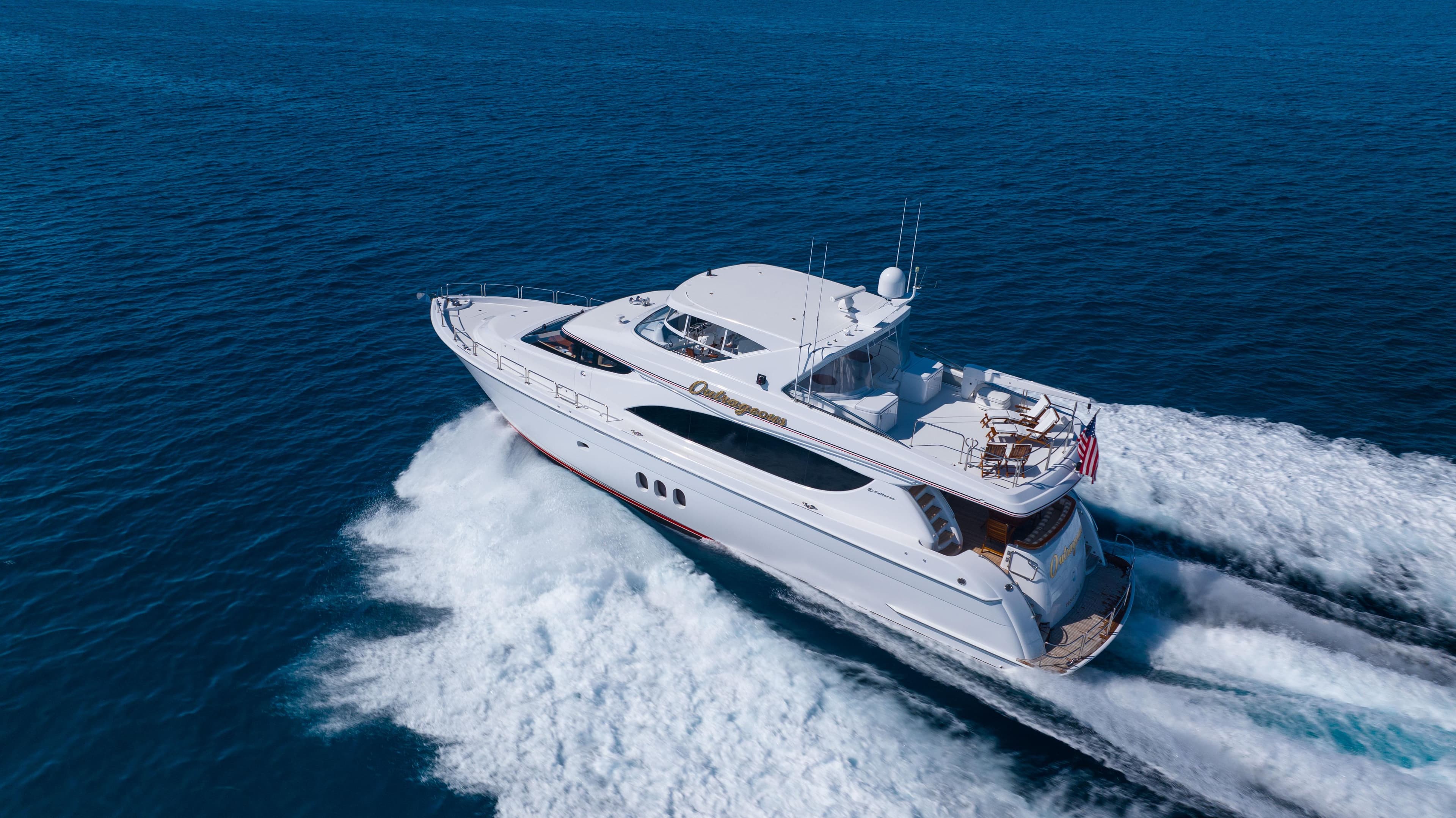 2005 Hatteras 80 Motor Yacht cruising on open sea, aerial view.