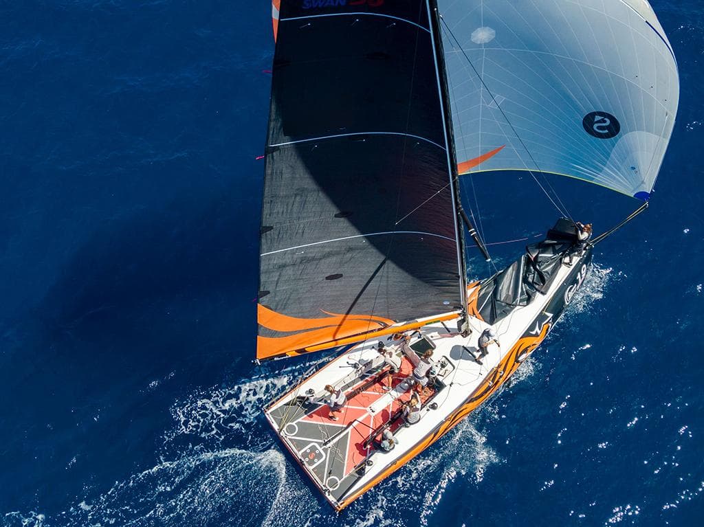 Aerial view of 2021 Nautor Swan ClubSwan 36 sailing on open blue sea.