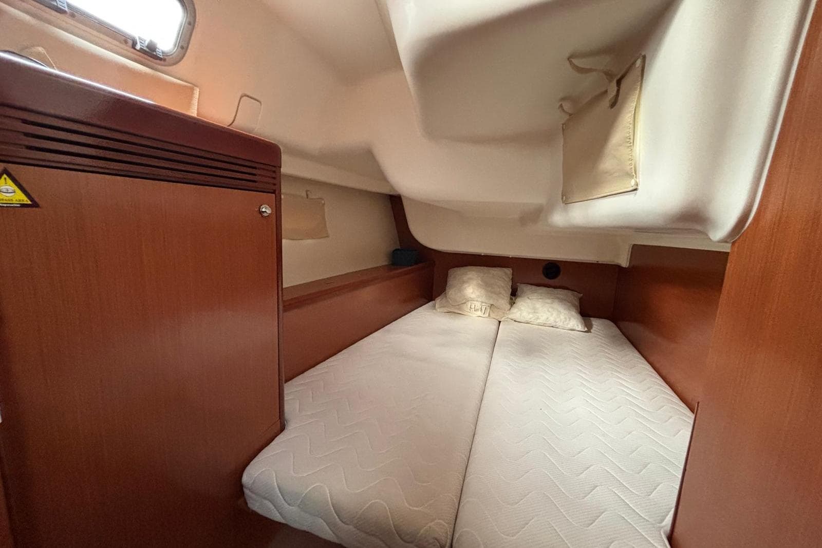 Cozy cabin interior of 2007 Beneteau Oceanis 40 sailboat with double bed and wooden finish.