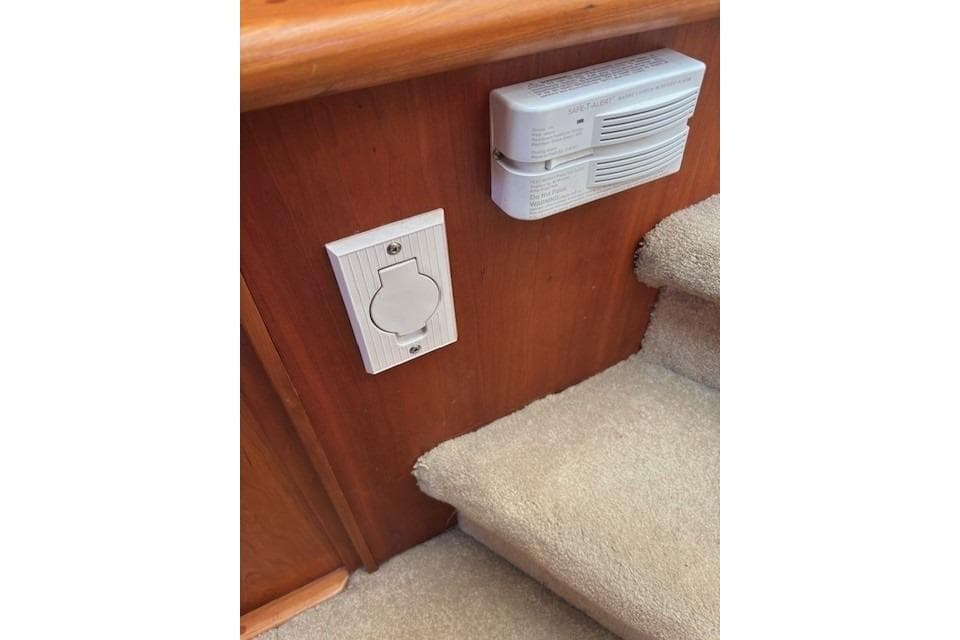 2004 Canoe Cove Sedan interior with outlet and smoke detector near carpeted stairs.
