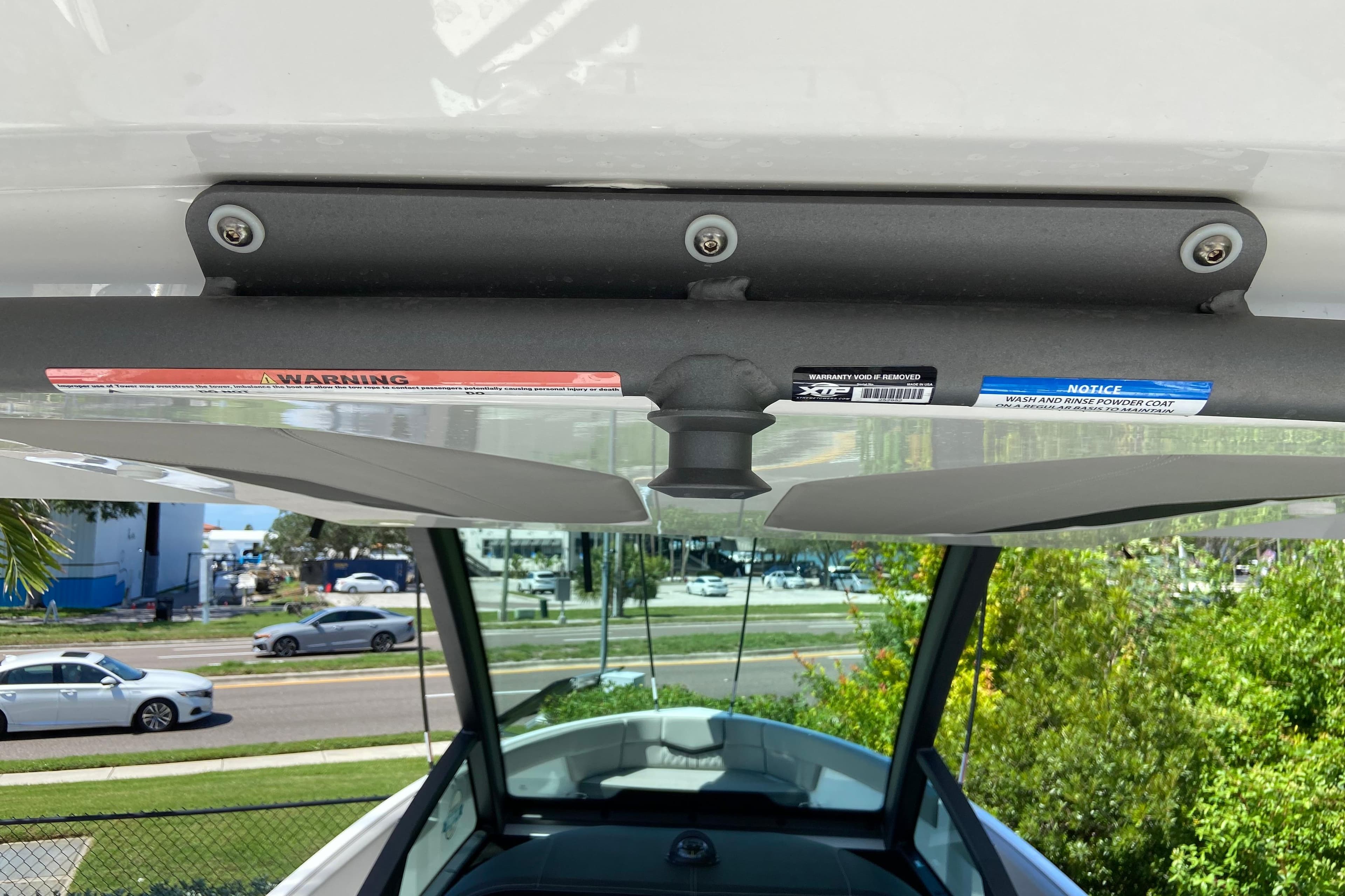 2026 Monterey Elite 25 OB boat interior view with warning labels and street background.