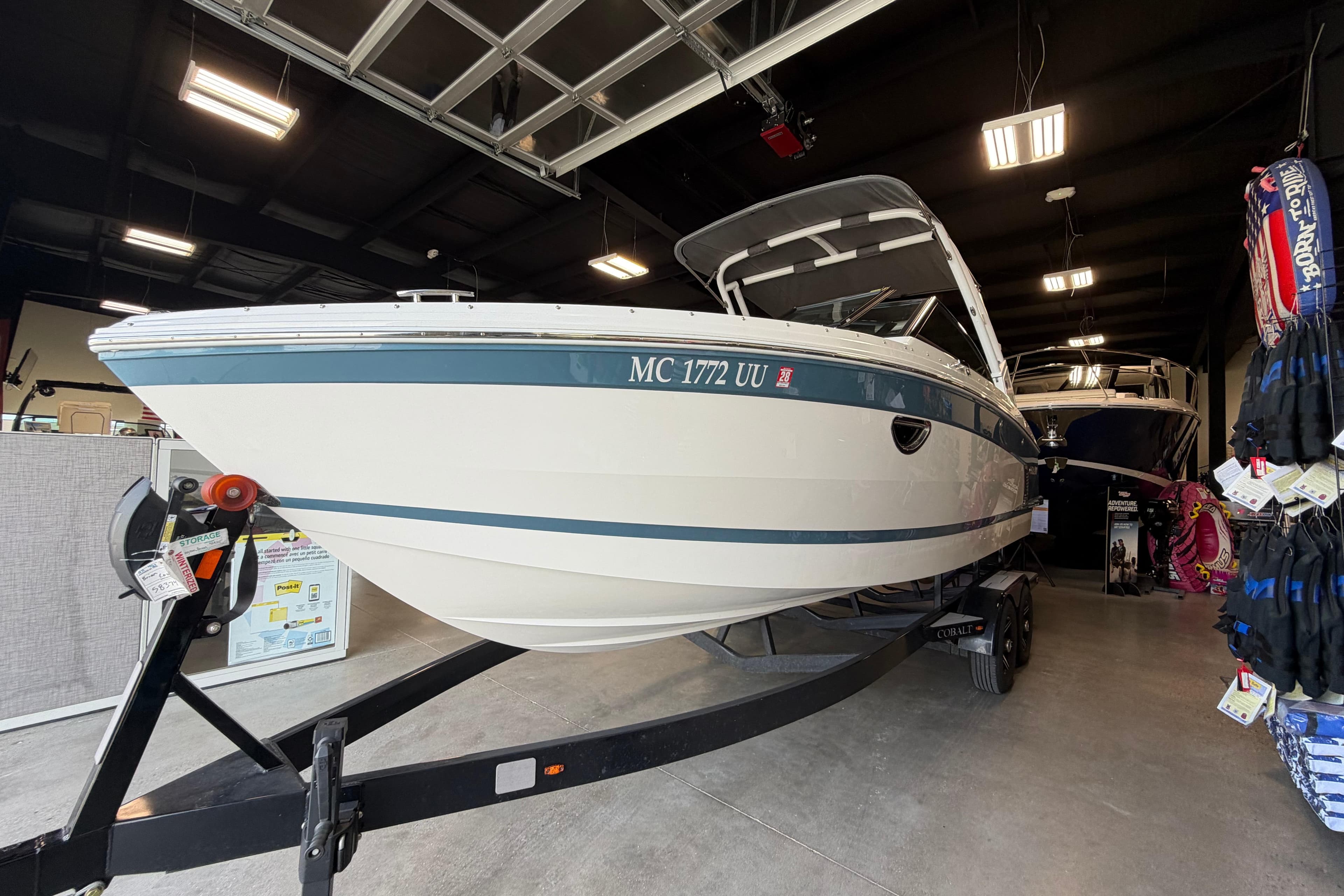2022 Cobalt R6 Surf boat displayed indoors on a trailer.