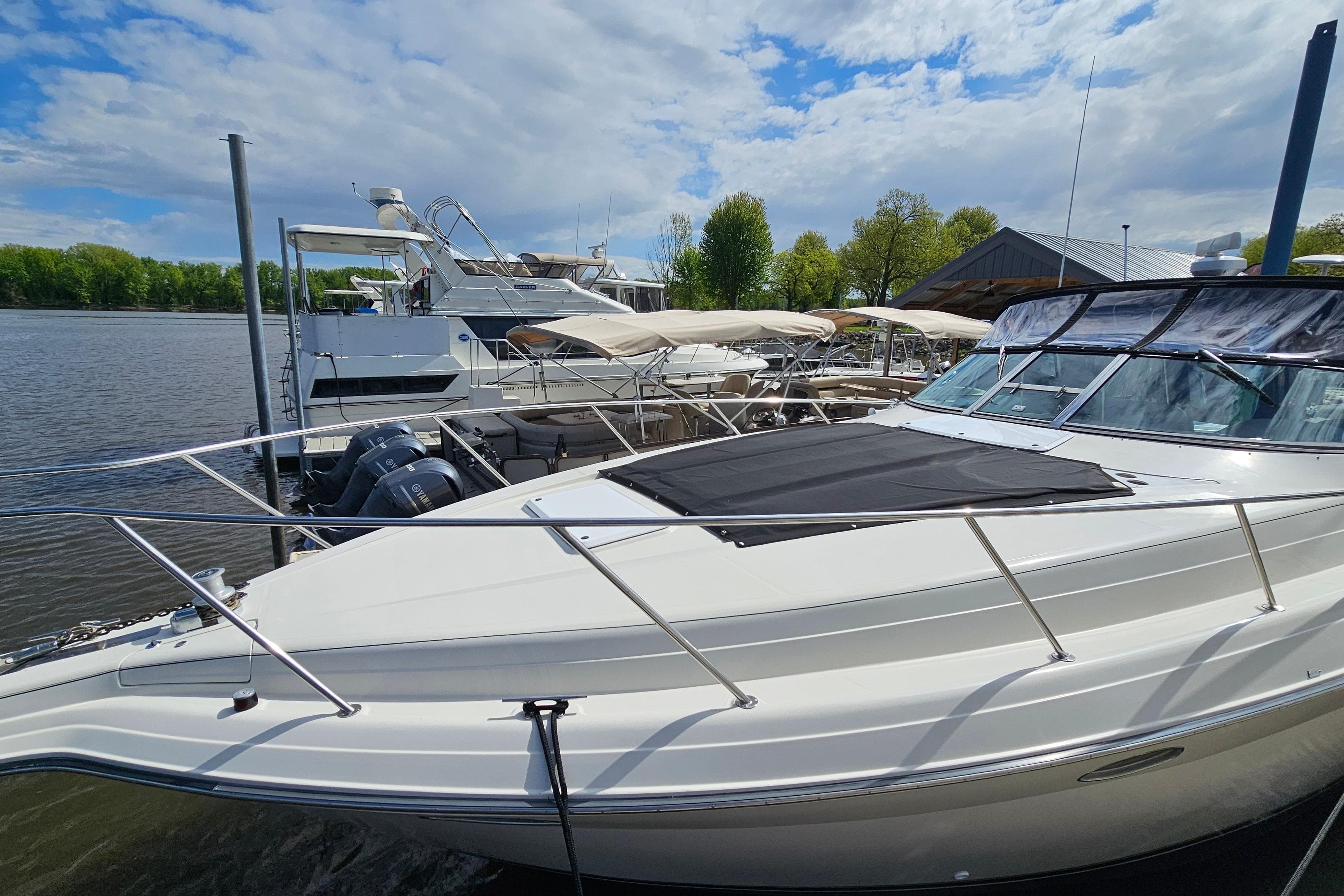 1997 Regal Commodore 402 yacht docked at marina under partly cloudy sky.