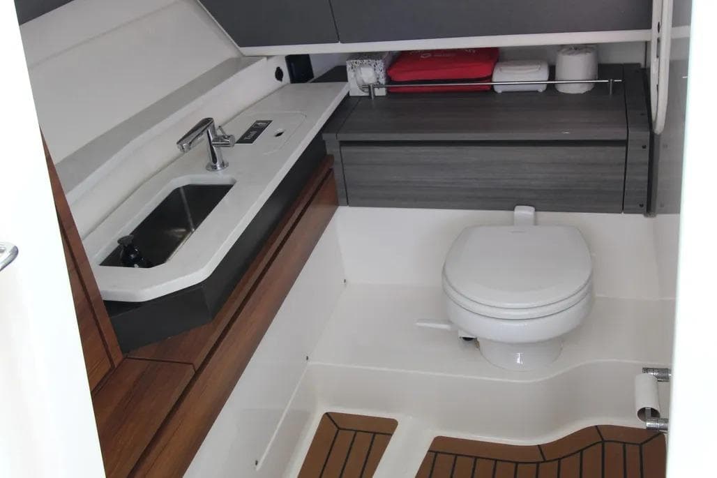2021 Tiara Yachts 38 LX bathroom with sink, toilet, and wooden flooring.