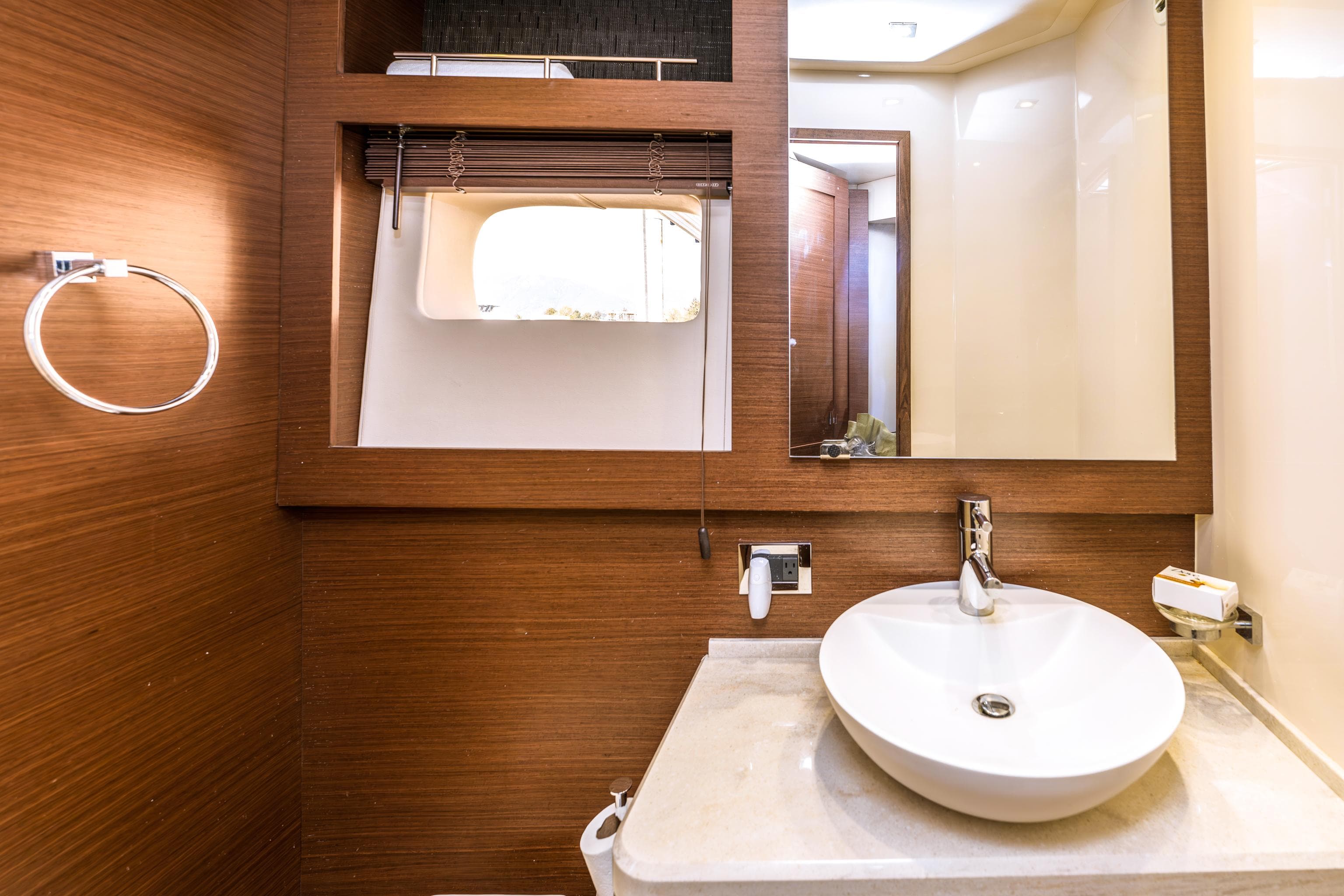 Luxurious bathroom interior of 2014 Sea Ray 510 Fly yacht with modern sink and wood accents.
