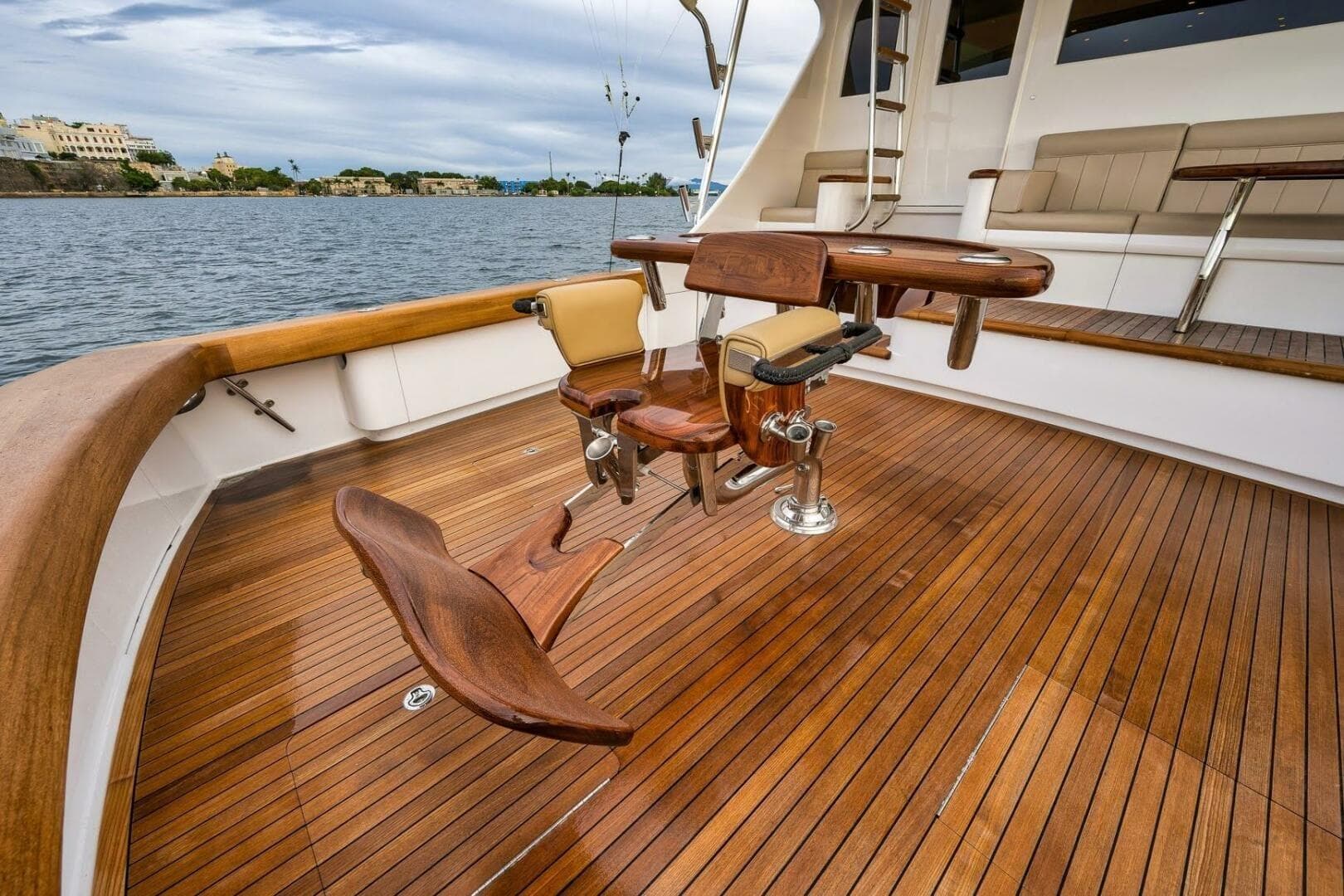Luxurious Weaver custom yacht deck with wooden flooring, fishing chair, and scenic waterfront view.