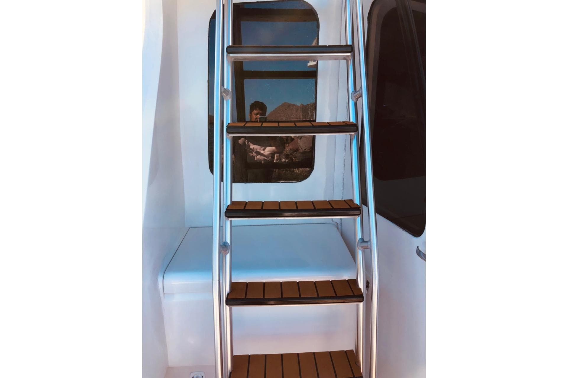 Staircase on 1999 Luhrs 38 Convertible yacht with wooden steps and metal railing.