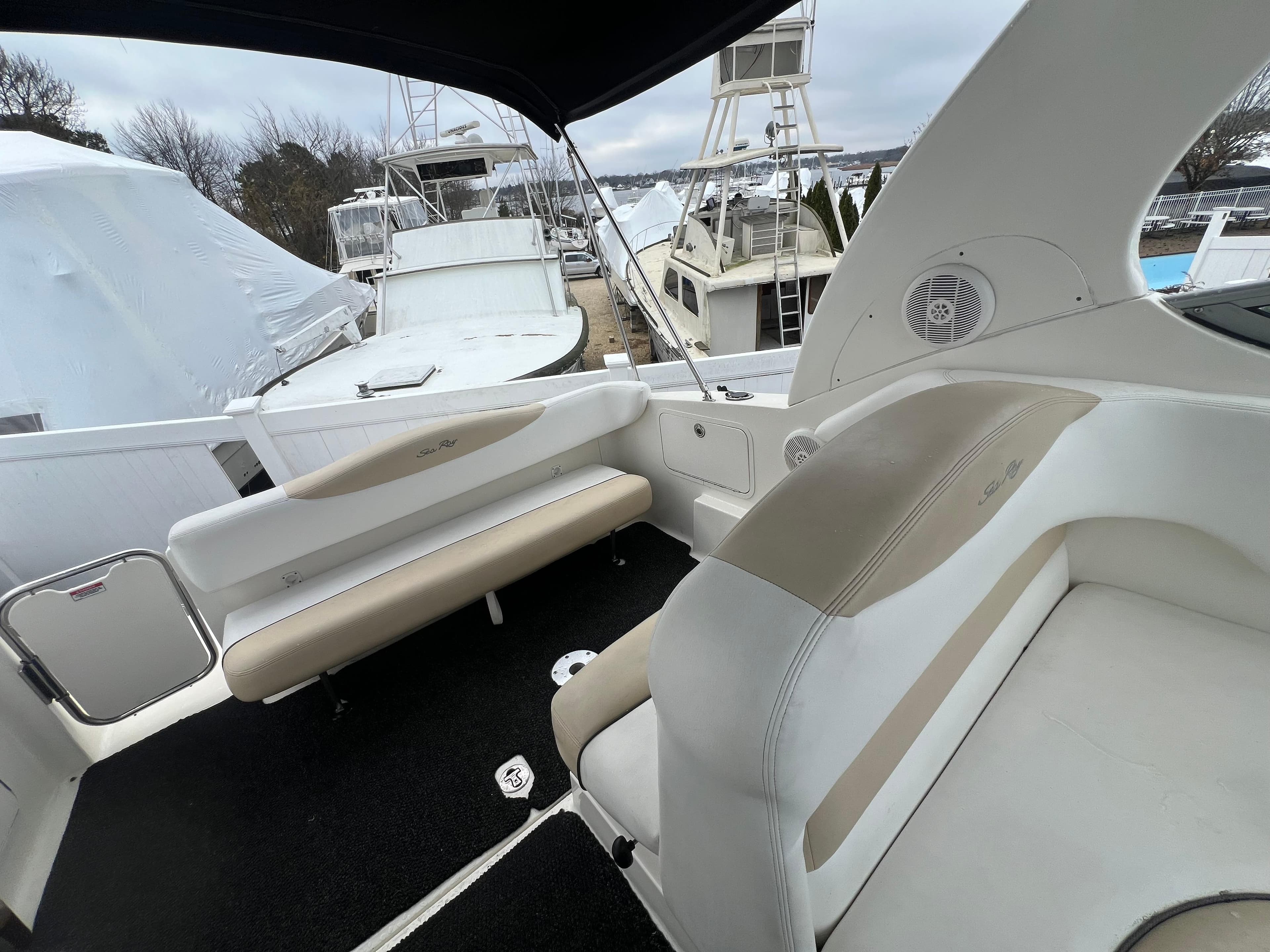 2008 Sea Ray 280 Sundancer boat interior with beige seating and black flooring.