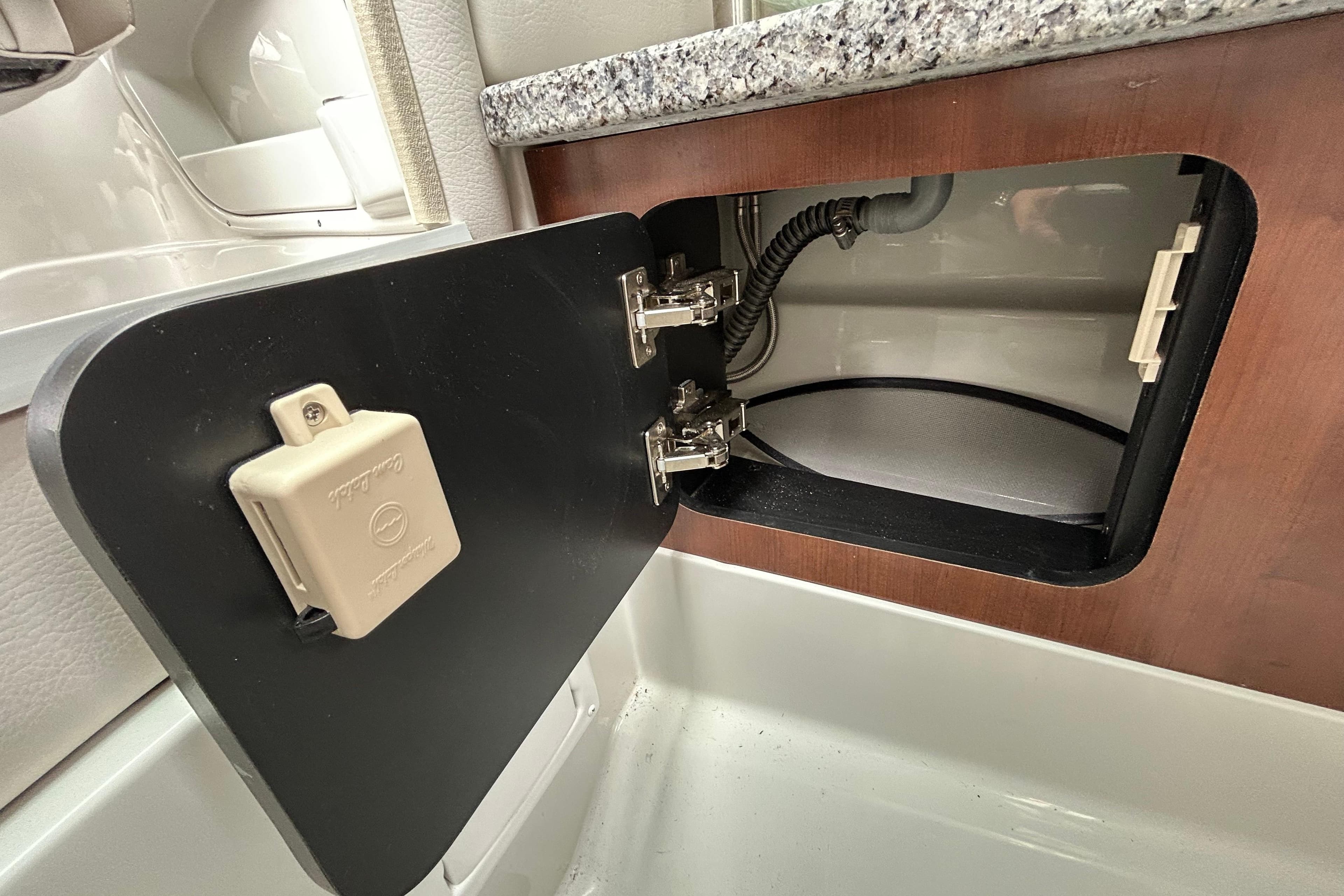 Open storage compartment in 2022 Crownline 270 XSS boat, featuring wood finish and secure latch.