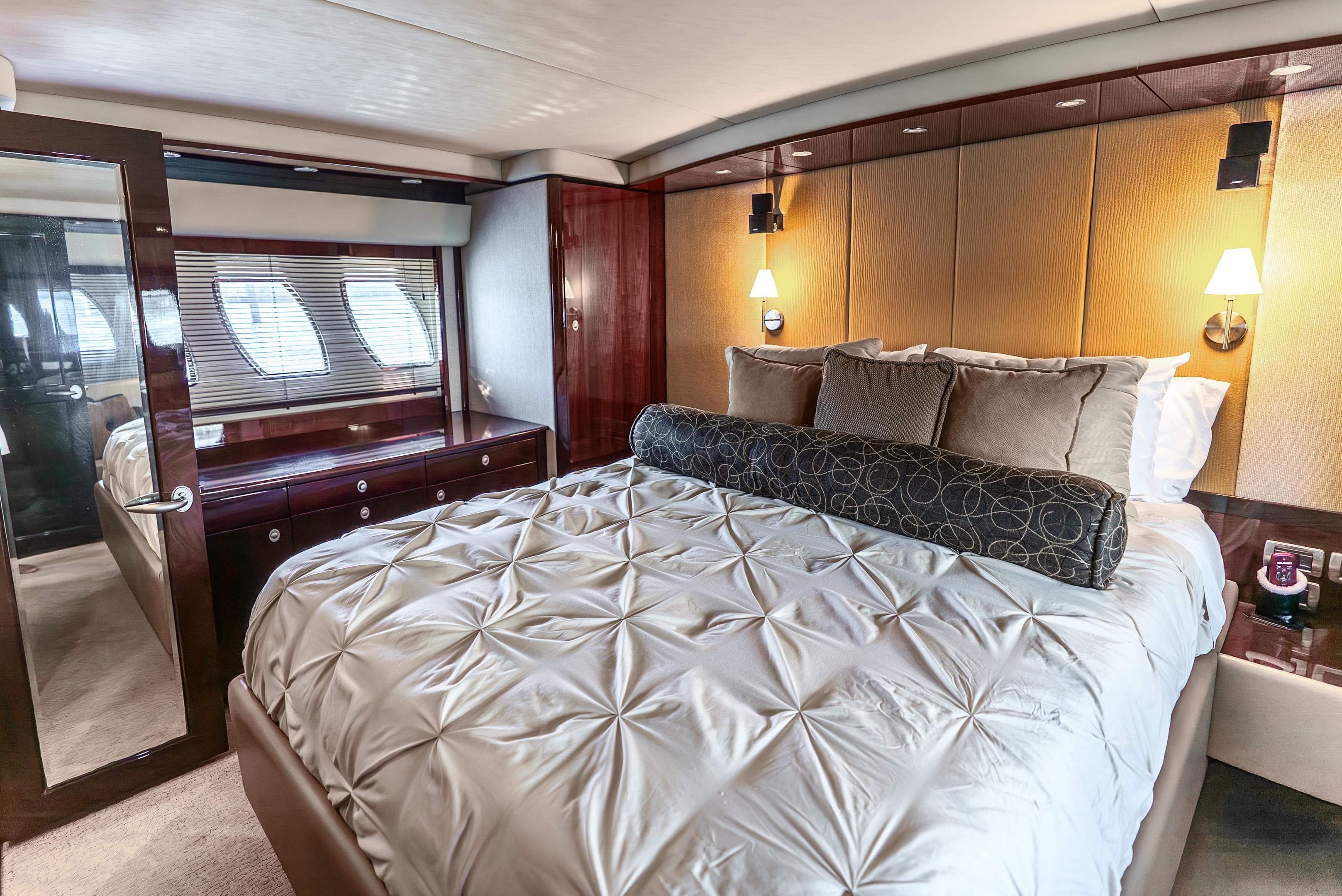 Luxurious bedroom interior of 2008 Sea Ray 60 Sundancer yacht with elegant bedding and lighting.