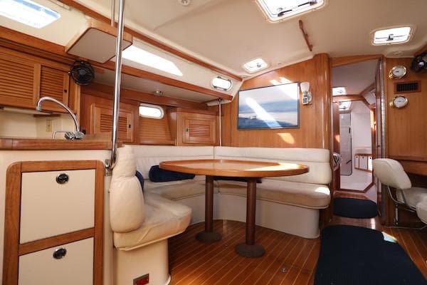 Interior of 2002 Catalina 42 MK 2 sailboat with wooden finishes and cozy seating area.