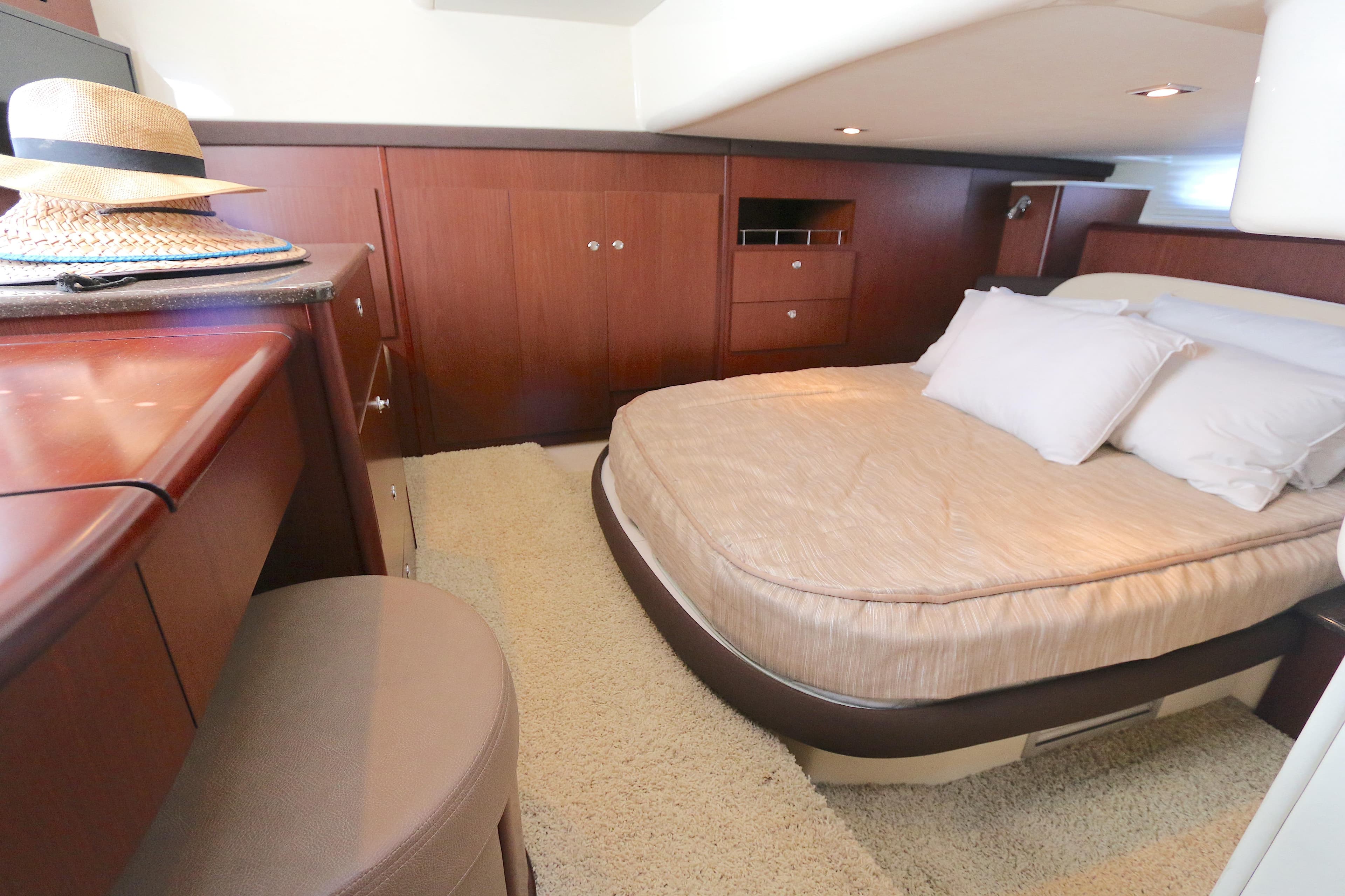 Luxurious bedroom interior of 2013 Meridian 441 Sedan yacht with elegant wood finish.