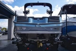 2025 MasterCraft XT22 T boat, rear view, parked at a marina.