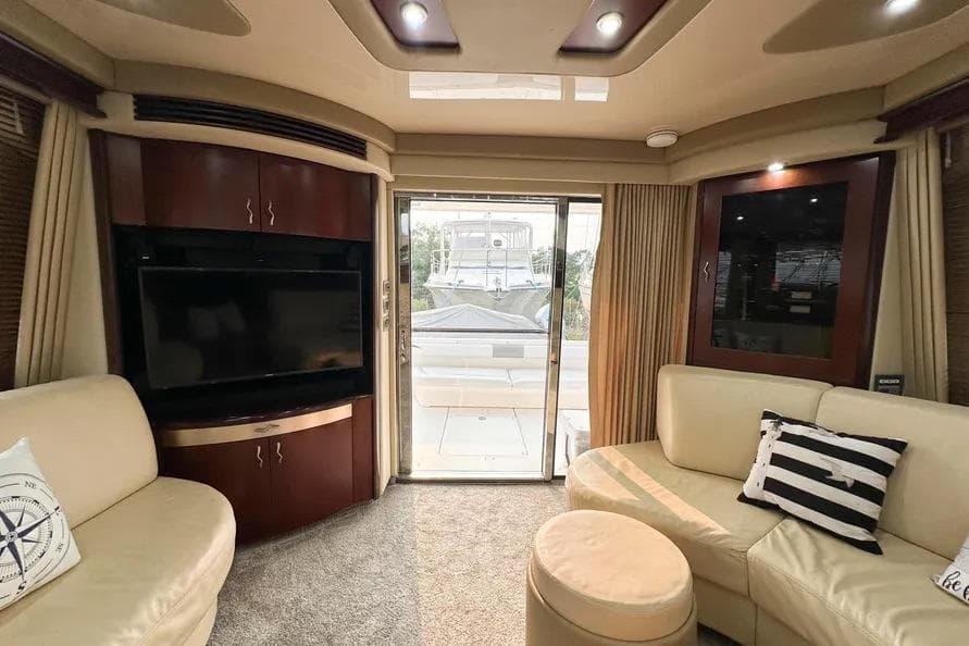 Luxurious interior of 2006 Sea Ray 580 Sedan Bridge yacht with plush seating and entertainment system.