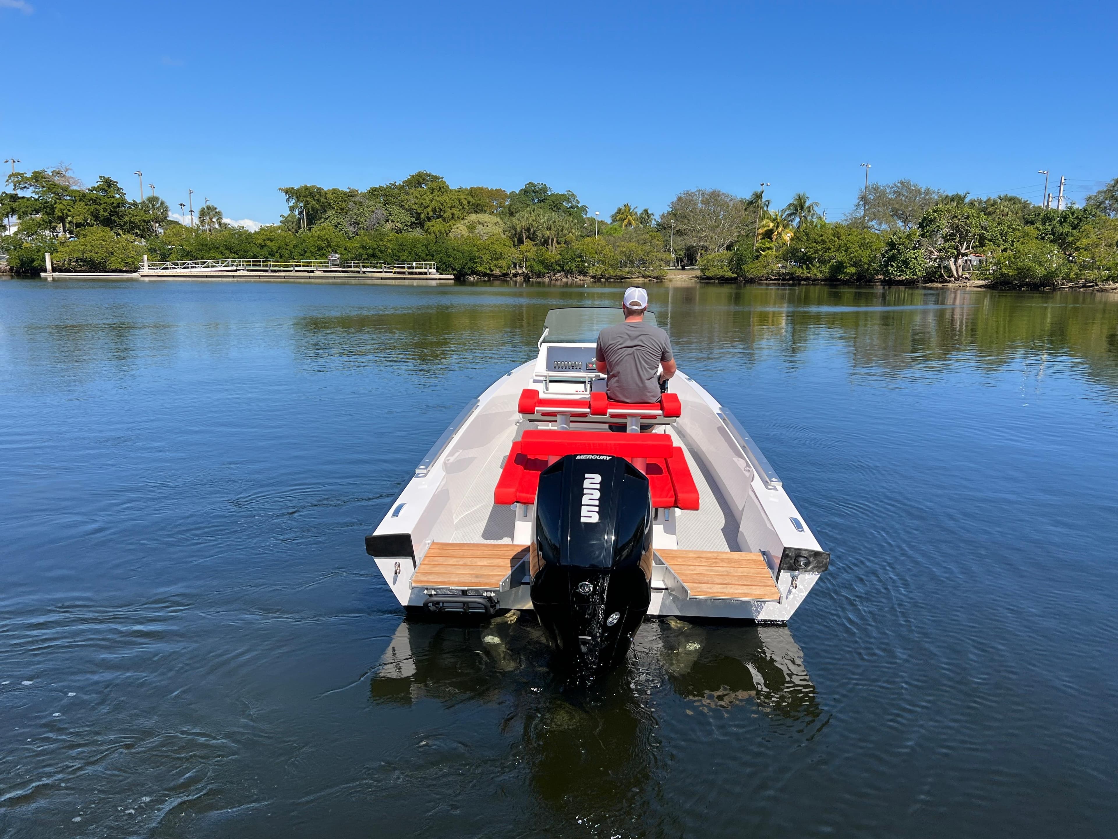 Man driving 2021 Goldfish 23 Tender boat on calm lake.