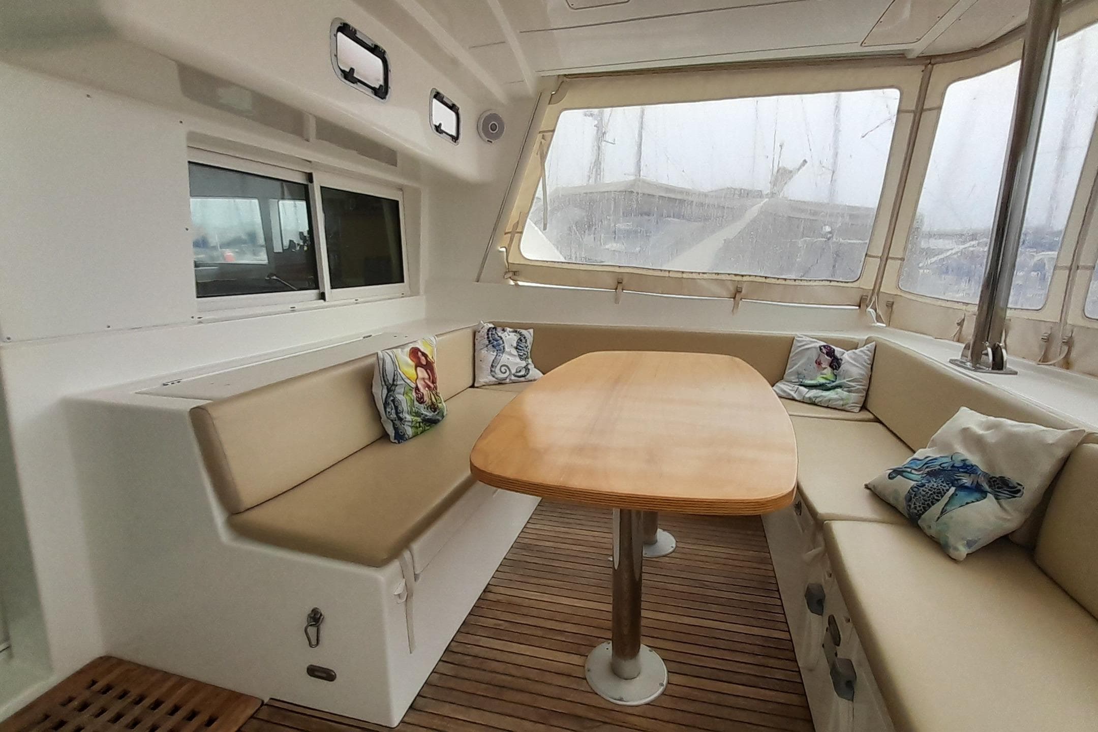 Spacious interior of 2008 Lagoon 440 catamaran with cozy seating and wooden table.