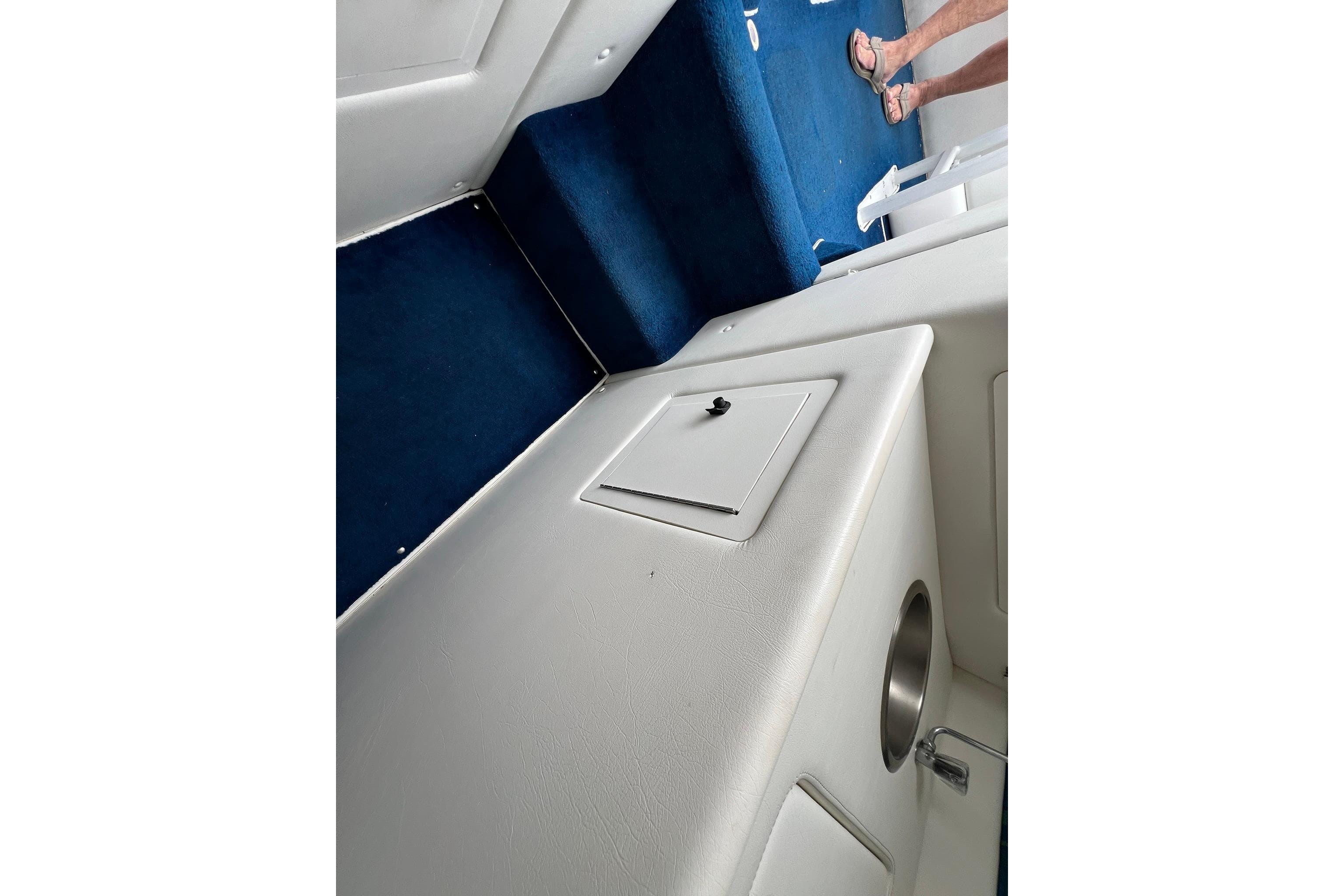 Interior of a 1997 Apache Warrior boat with blue carpet and white paneling.