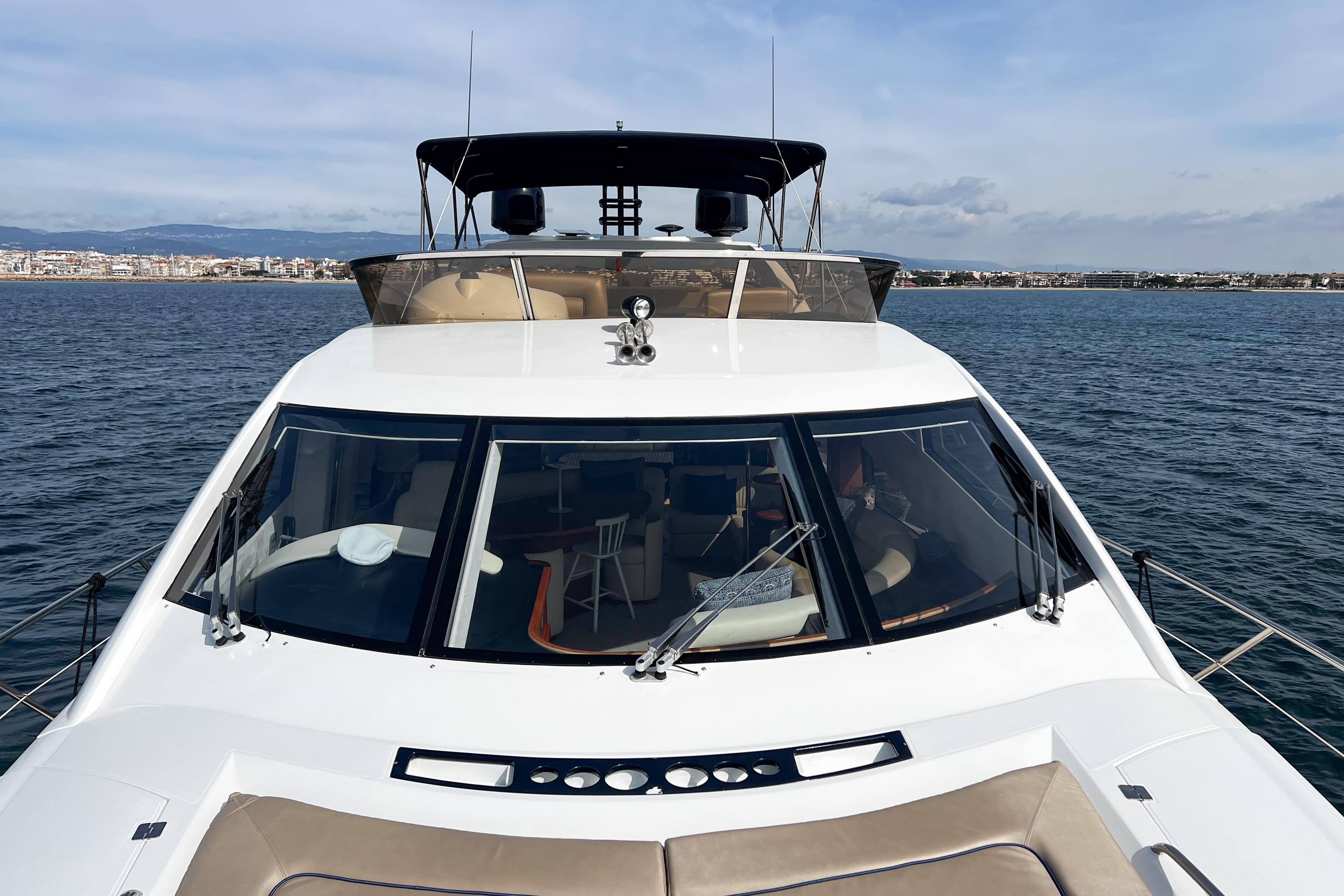 2007 Sunseeker Manhattan 66 yacht on calm waters, cityscape in background.