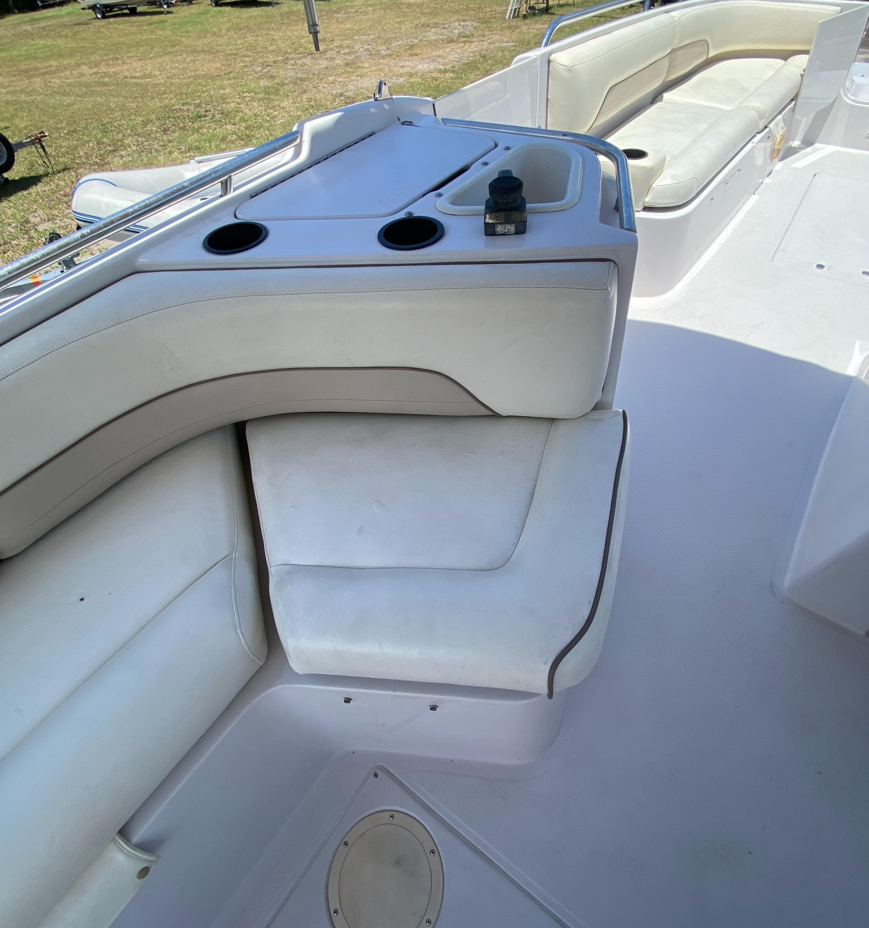 1997 Chaparral 250 Sunseta boat interior with white seating and cup holders.