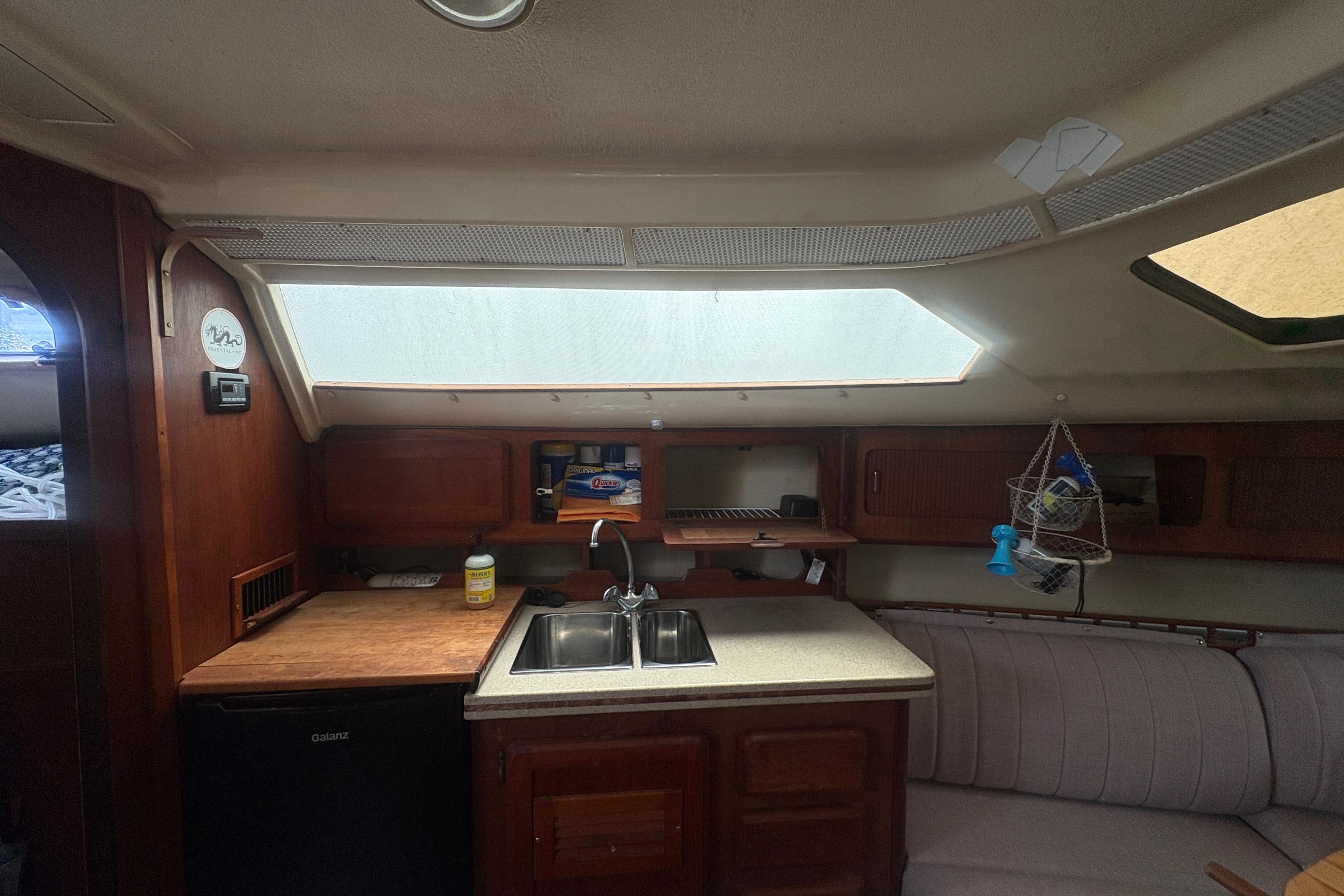 Interior of 1989 Hunter Vision 32 sailboat kitchen with sink, cabinets, and seating area.