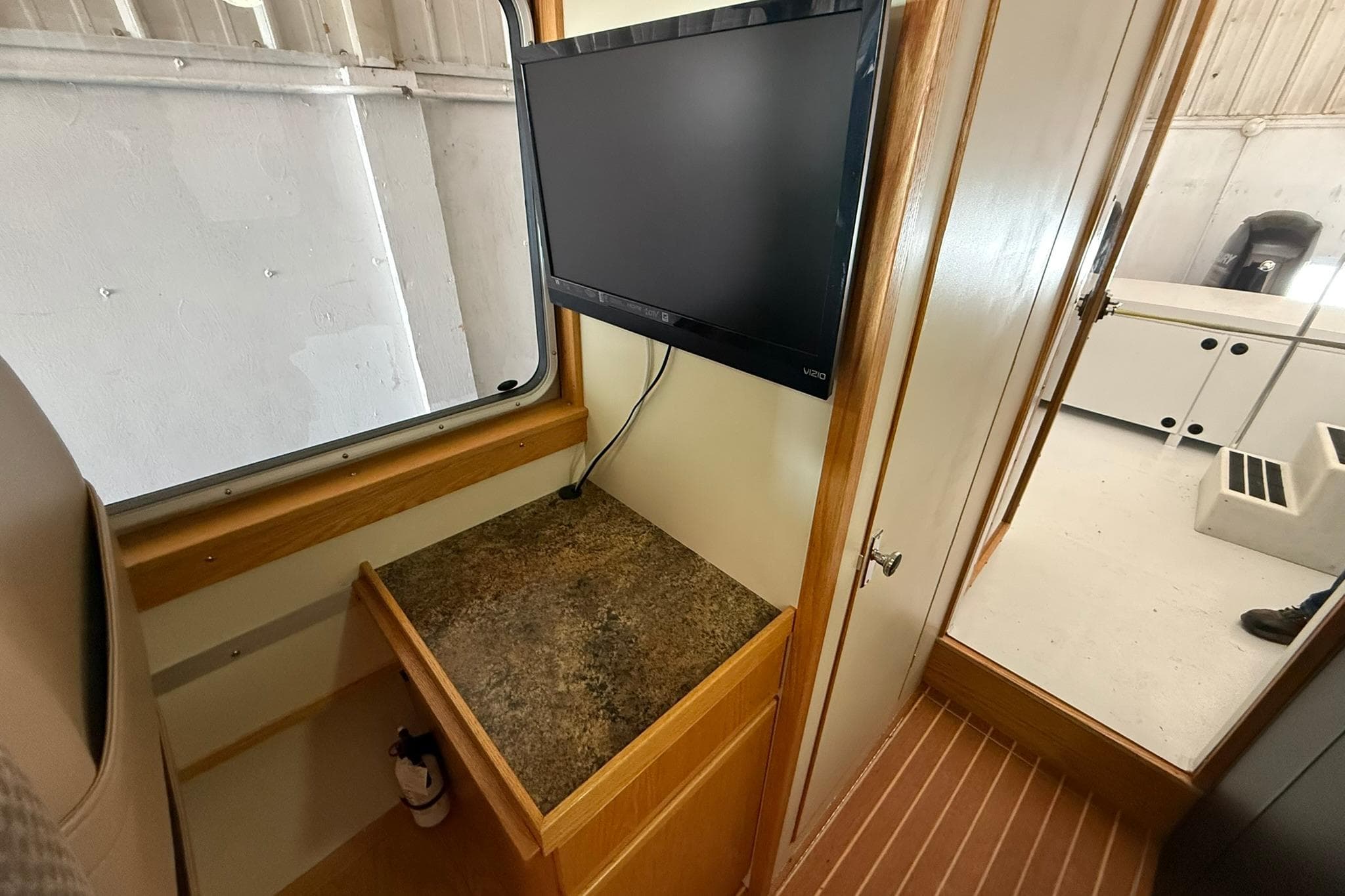Interior of 2013 Eco-Trawler 33 with mounted TV and wooden cabinetry.