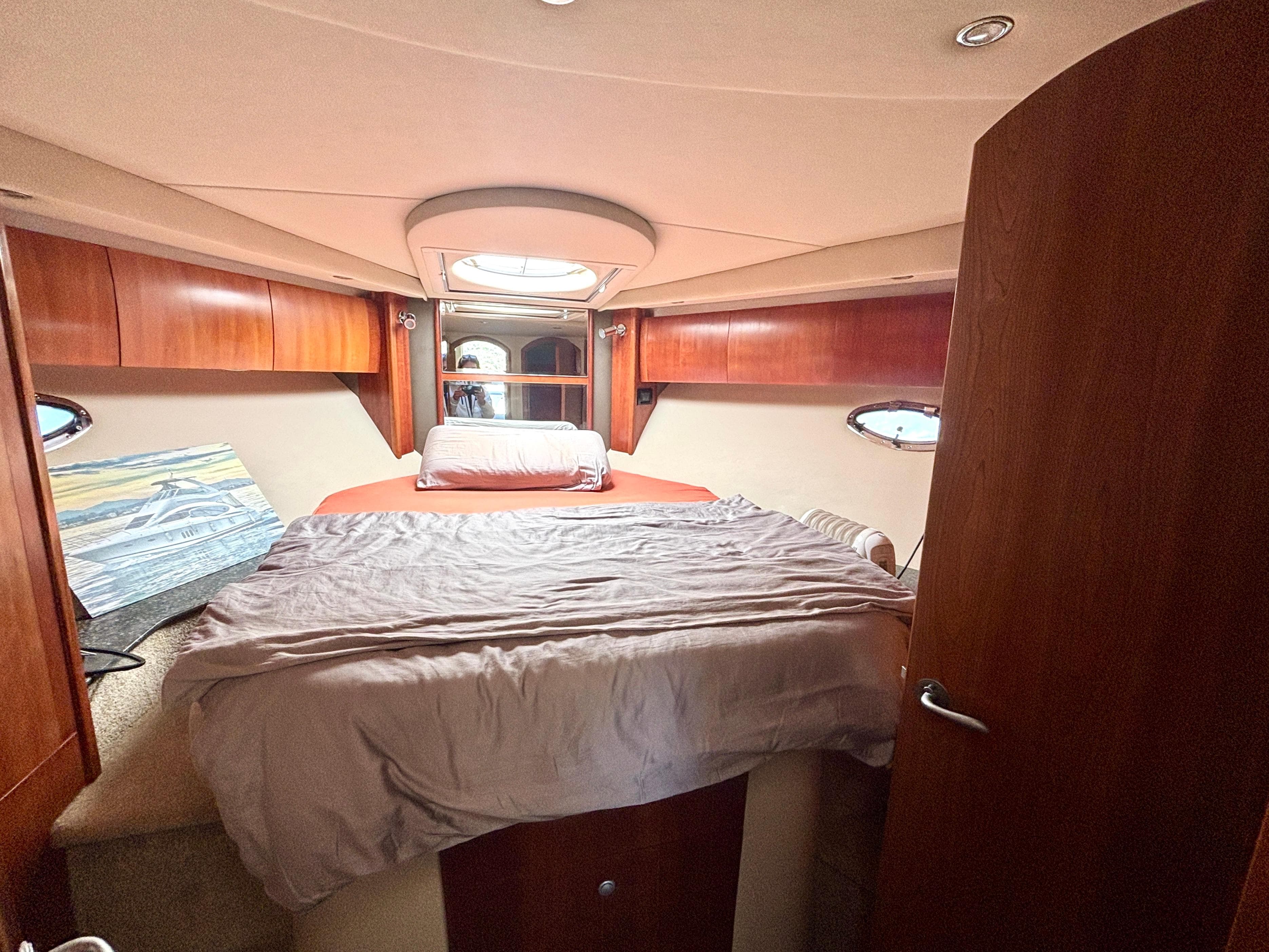 2007 Cruisers Yachts 447 Sport Sedan cabin with bed, wood paneling, and portholes.