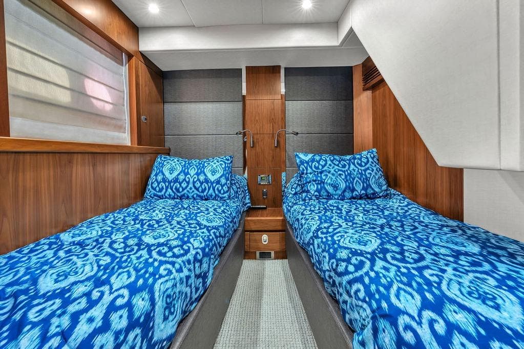 Luxurious twin cabin in 2016 Sunseeker Manhattan 55 yacht with blue patterned bedding.