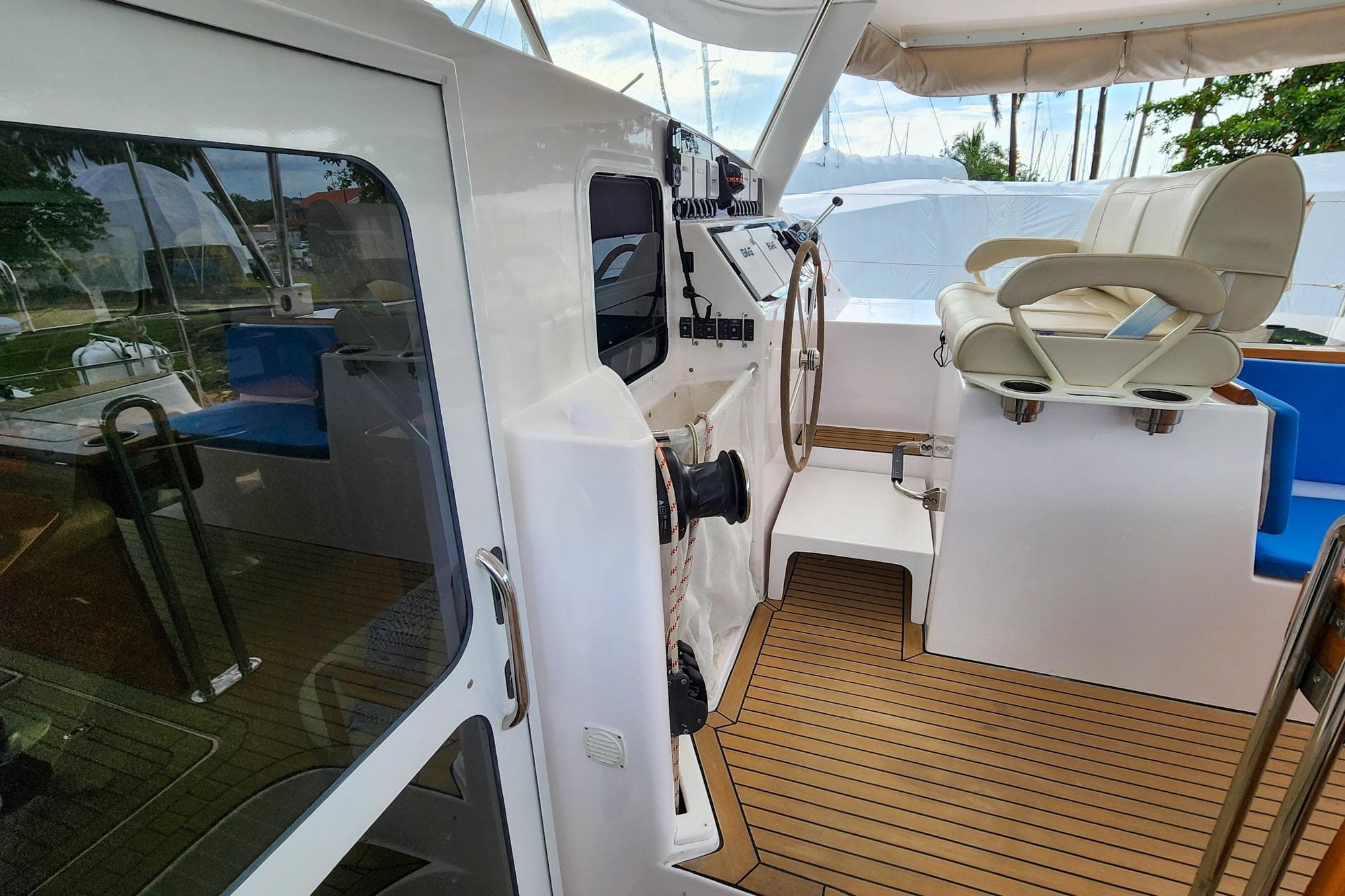 2022 Antares Hybrid yacht cockpit with steering wheel and seating on teak deck.