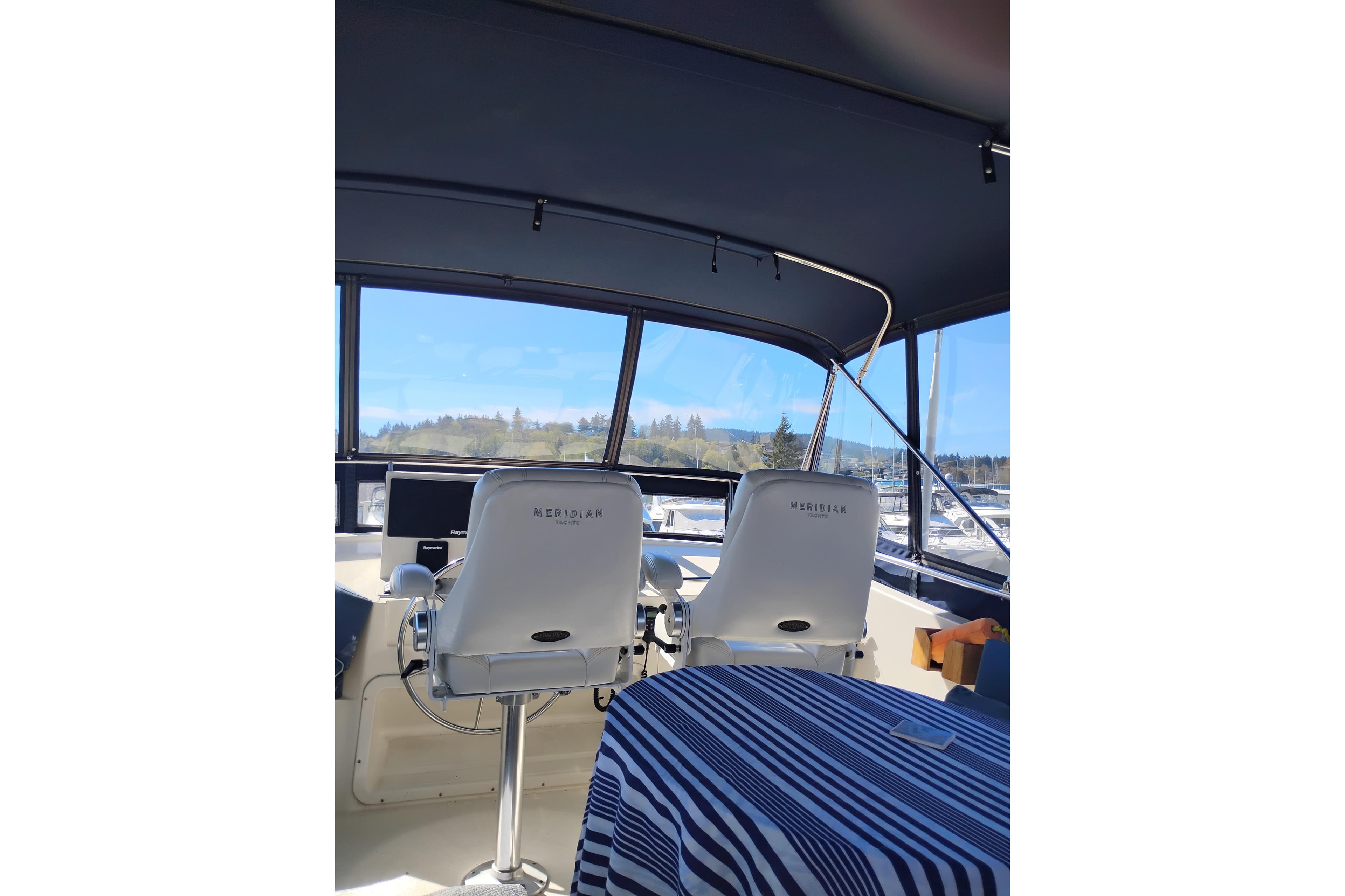 1988 PT 52 AFT Cabin Motor Yacht interior with helm chairs and striped tablecloth.
