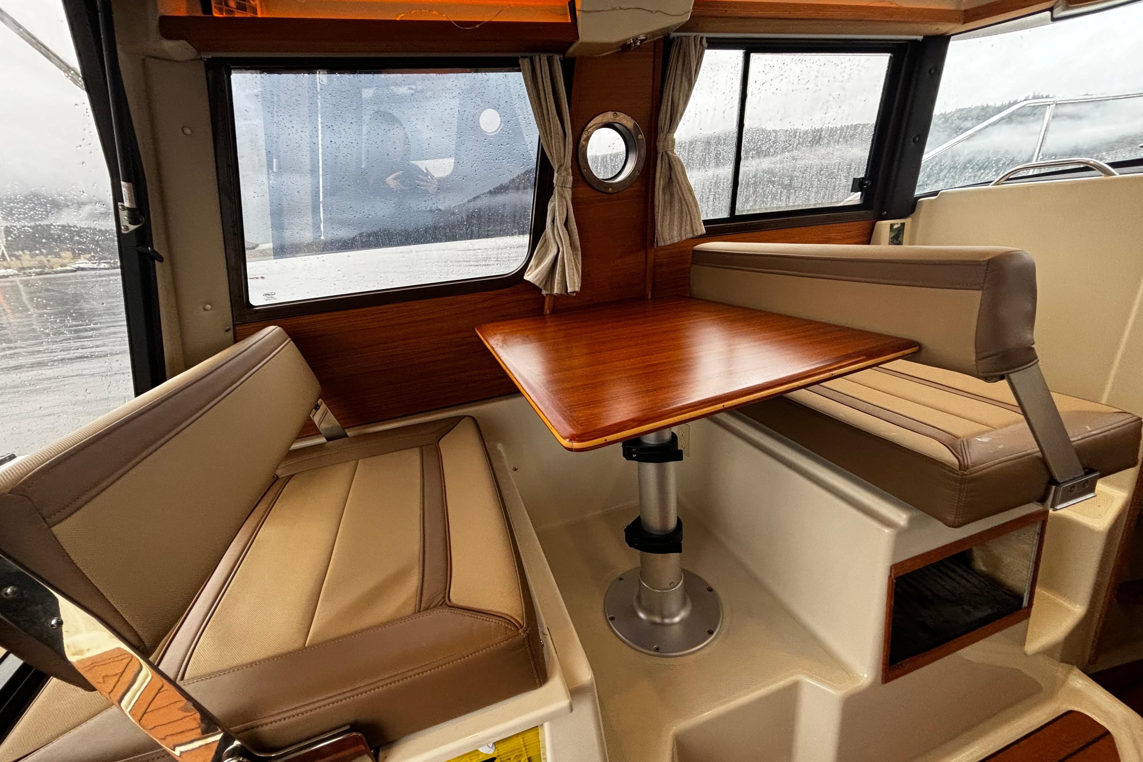 2022 Ranger Tugs R-23 interior with cozy seating and wooden table.