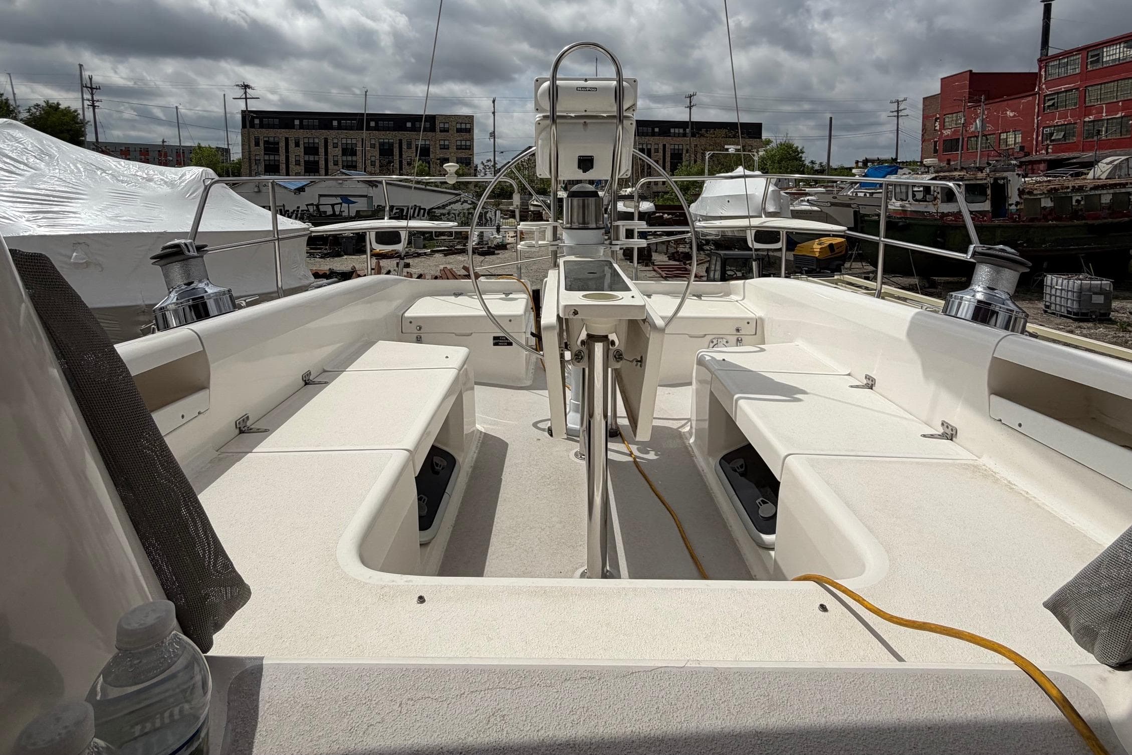 Cockpit view of a 2001 Catalina 380 sailboat, docked under cloudy skies.