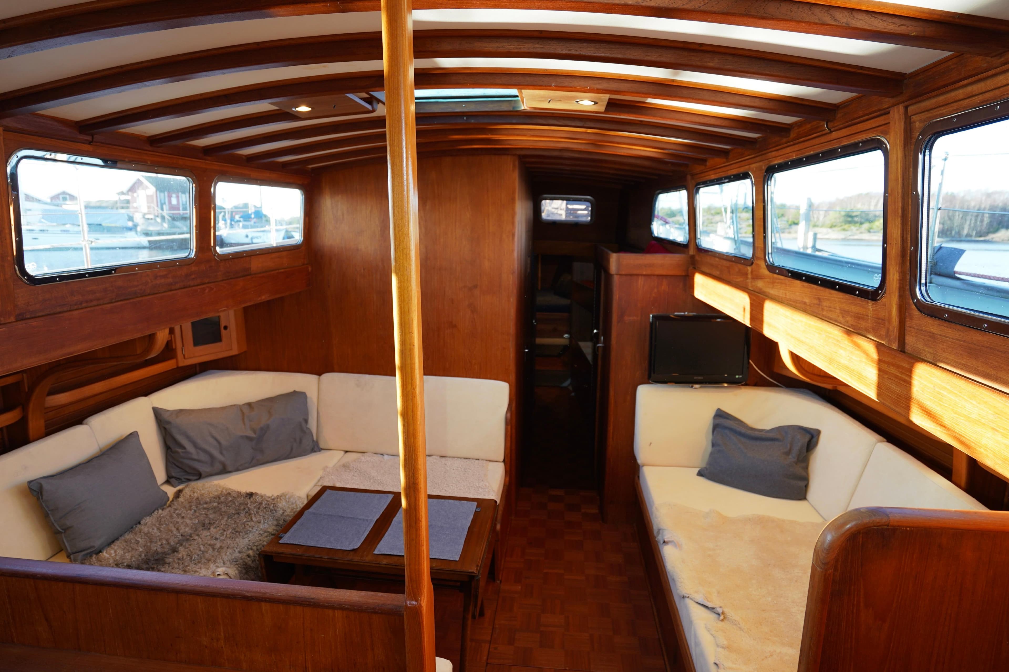 Interior of 1977 Van Dam De Vries Lentsch 57 Classic Ketch with wooden finish and cozy seating.