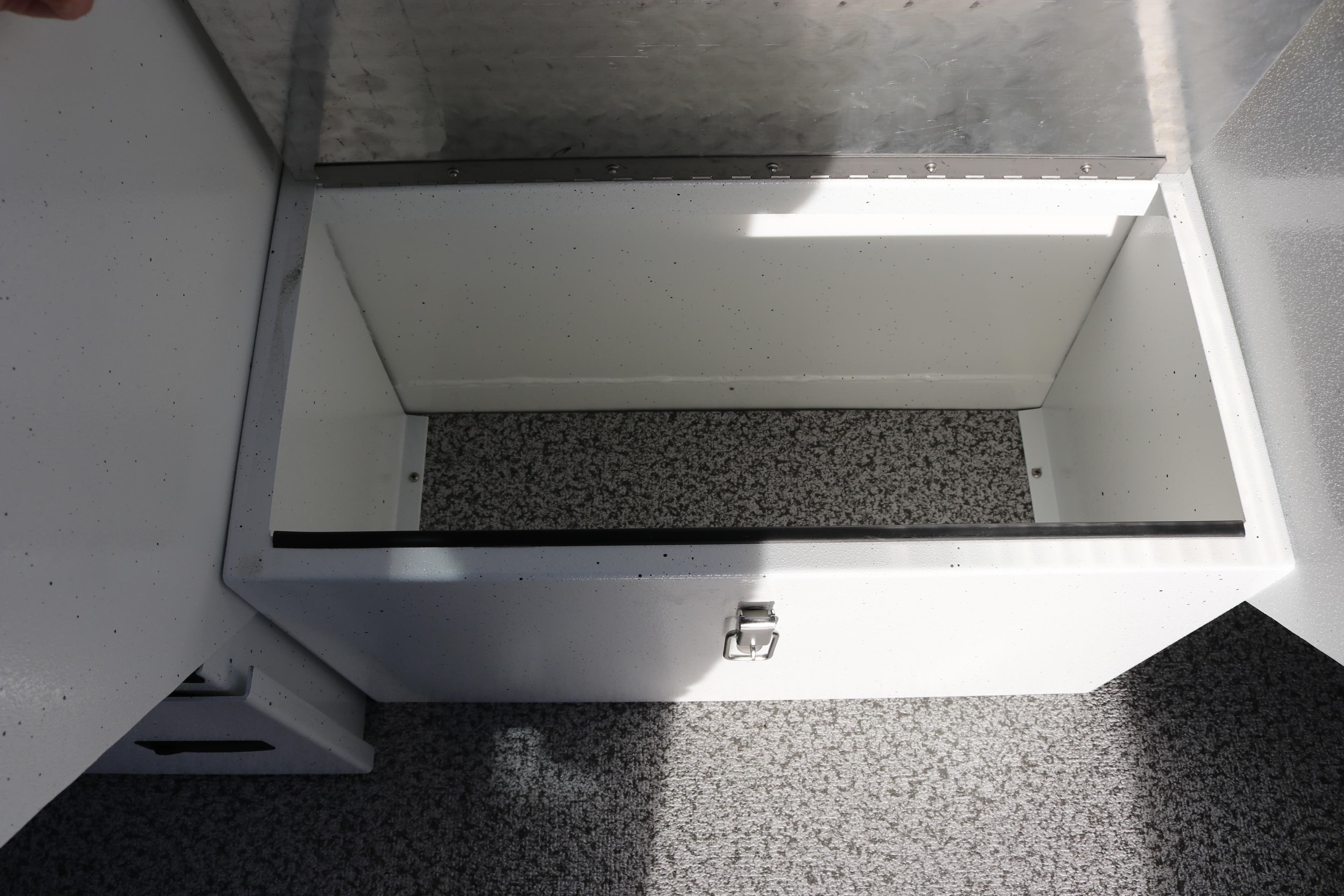 Open storage compartment in 2026 Alumaweld Intruder Outboard 22 boat, featuring a secure latch.