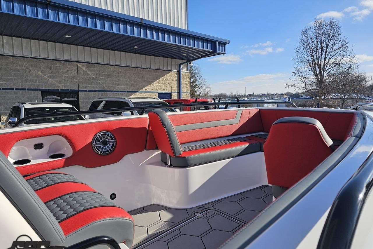 Luxurious interior of 2025 Concept 27' CC boat with red and gray seating.