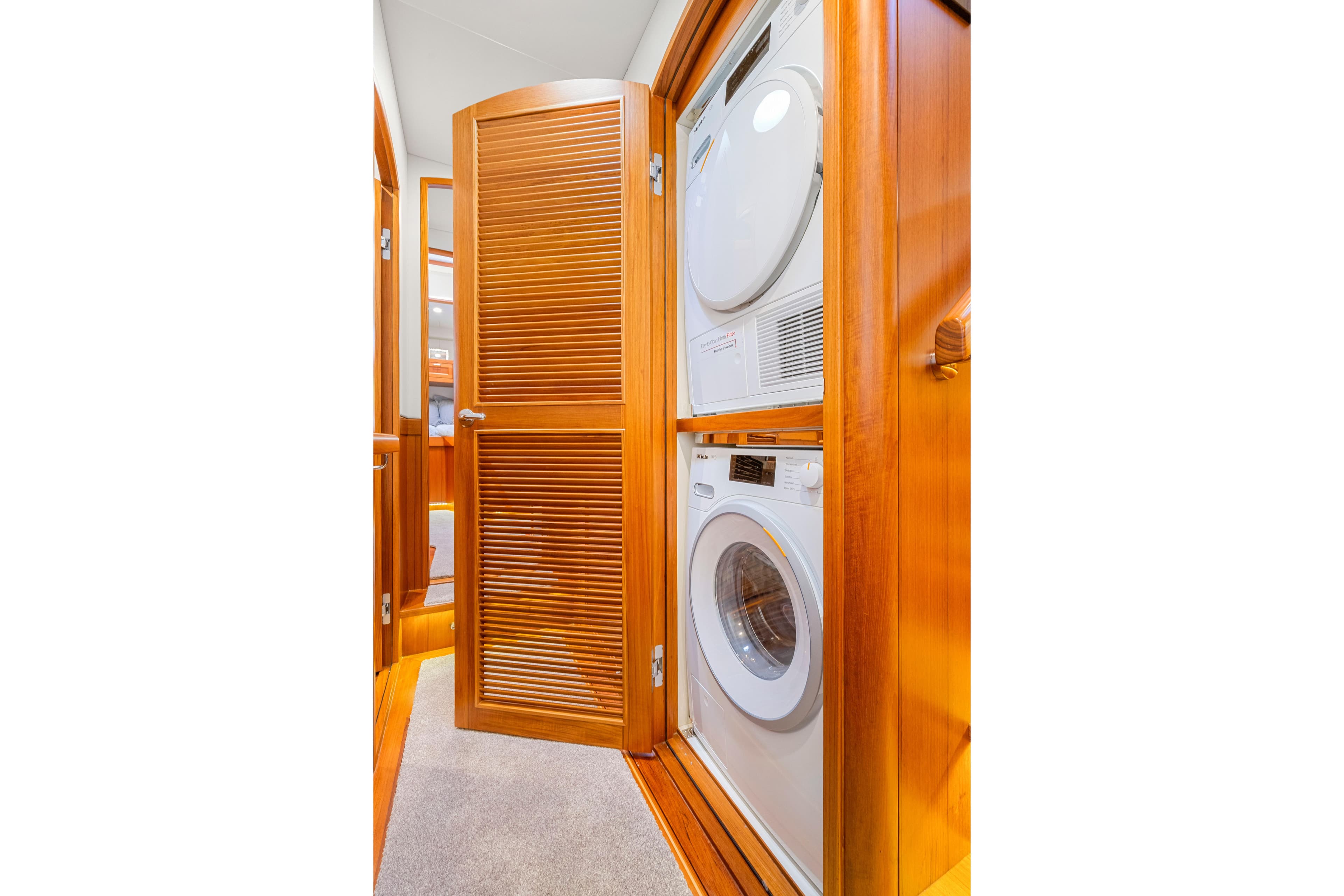 Laundry area with stacked washer and dryer in 2023 Fleming 85 yacht.