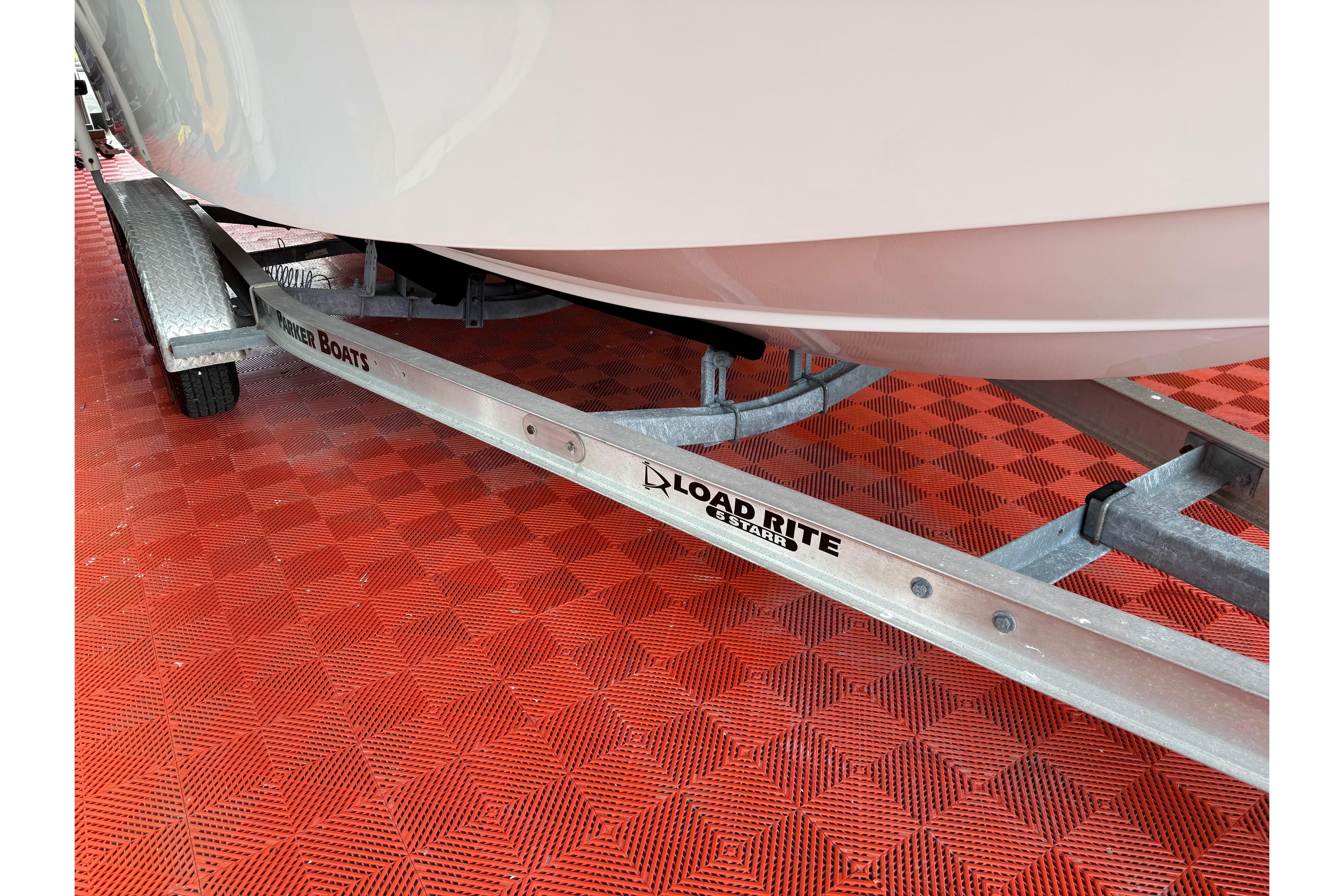 2018 Parker 2100 SE boat on Load Rite trailer, red checkered floor.