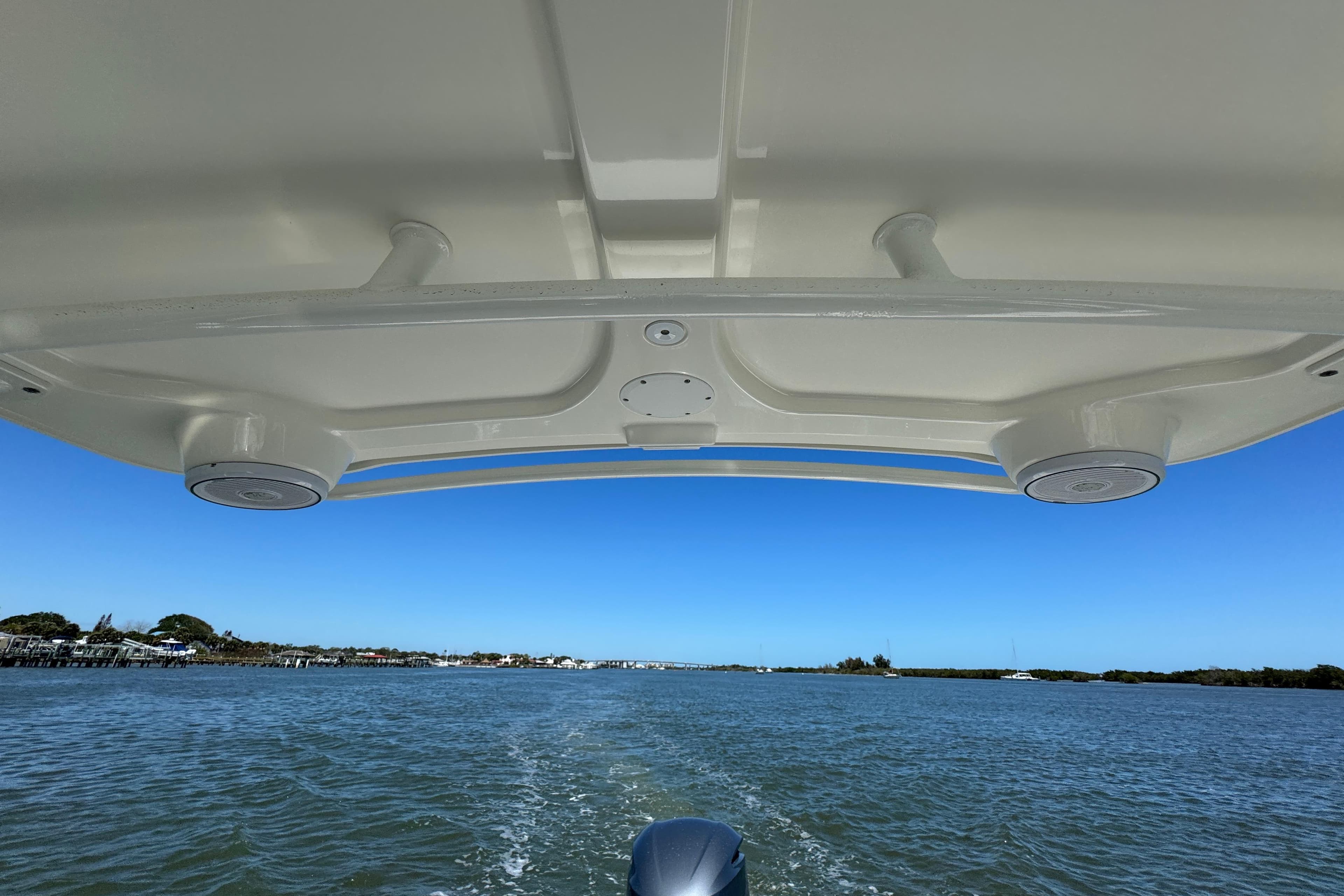 Edgewater 245CX Crossover boat cruising on a sunny day, view from under the canopy.
