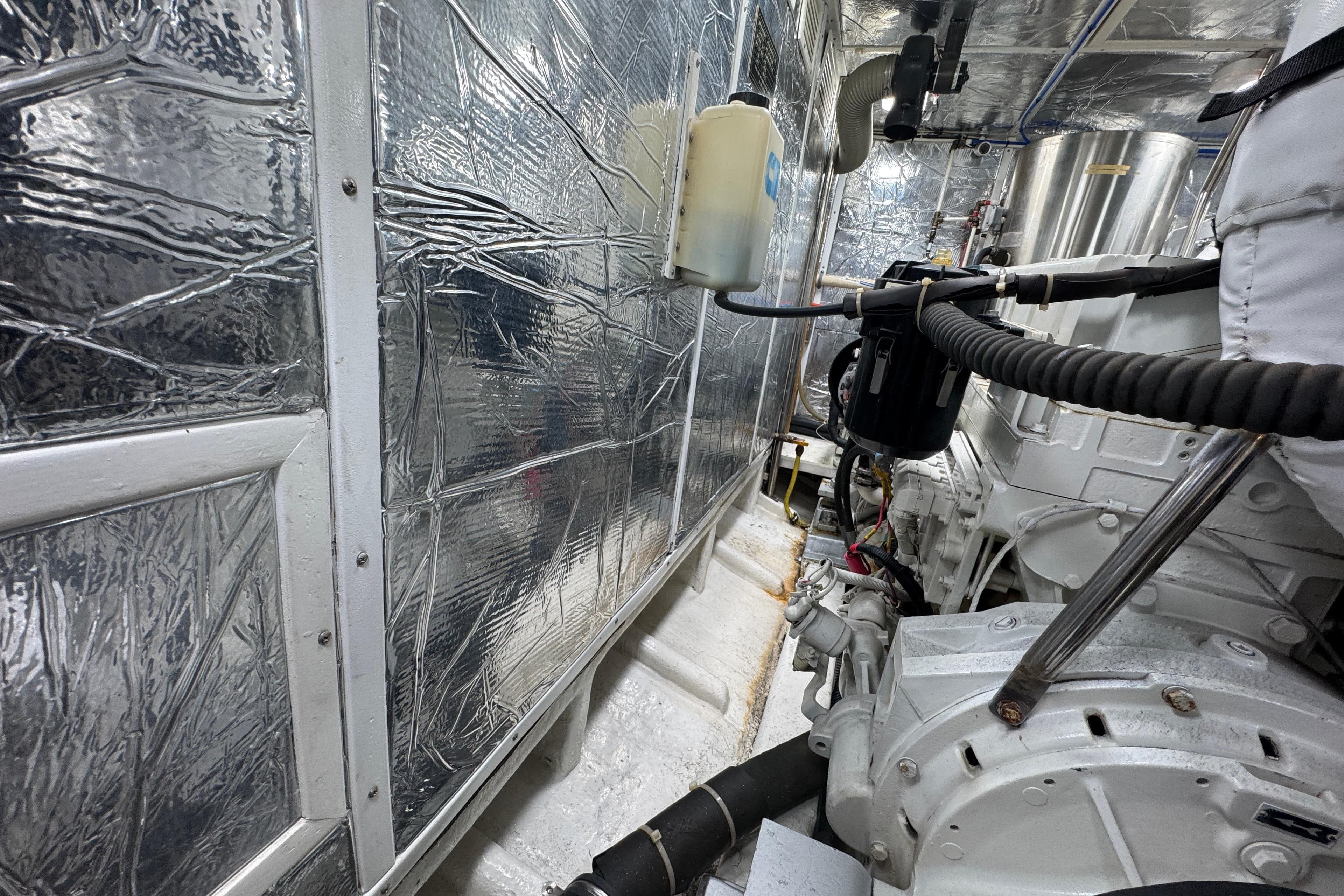 Engine room of 2003 Altima 55 Pilothouse with metallic insulation and machinery.
