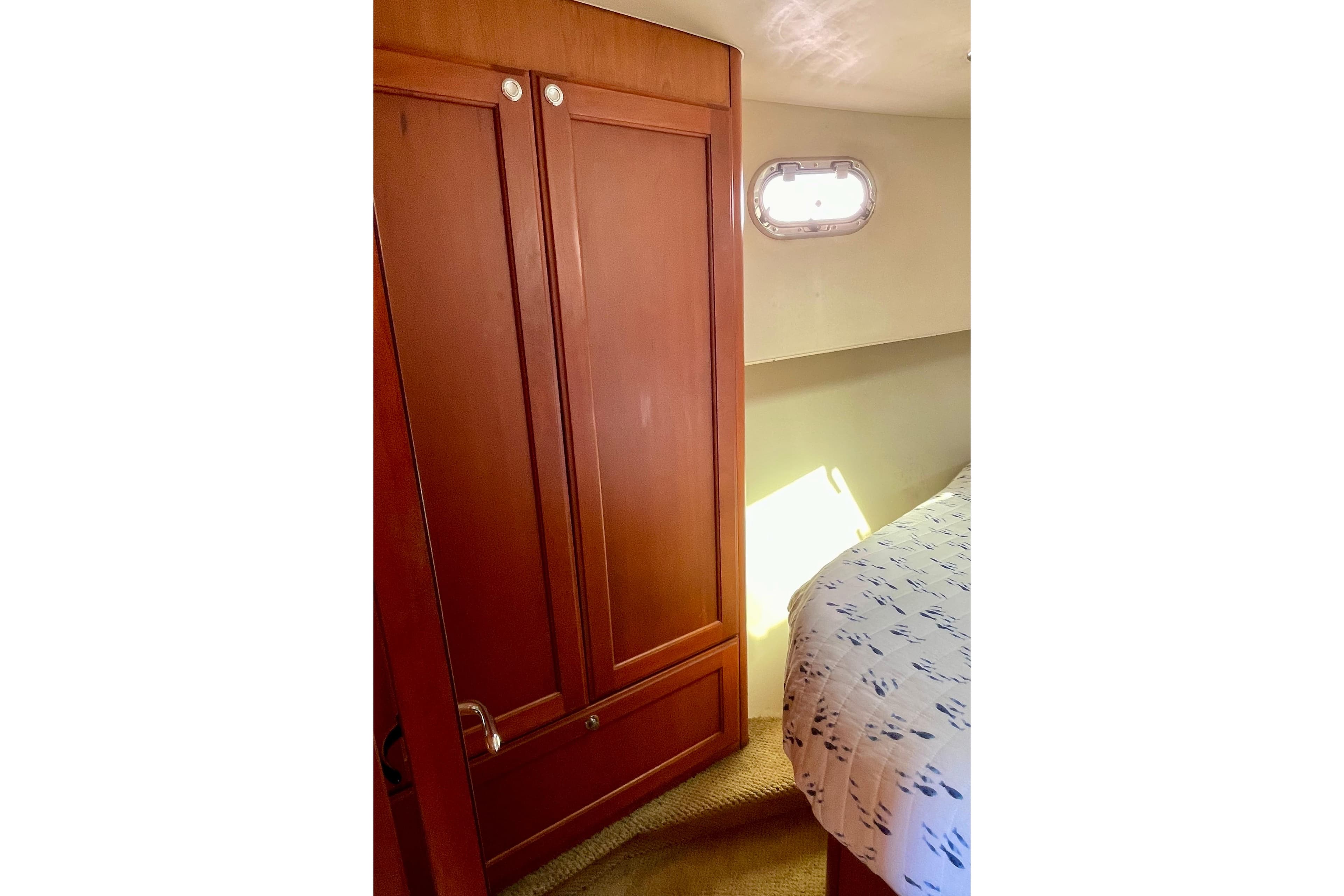 Interior cabin of 2008 Mainship 34 Trawler with wooden closet and bed.