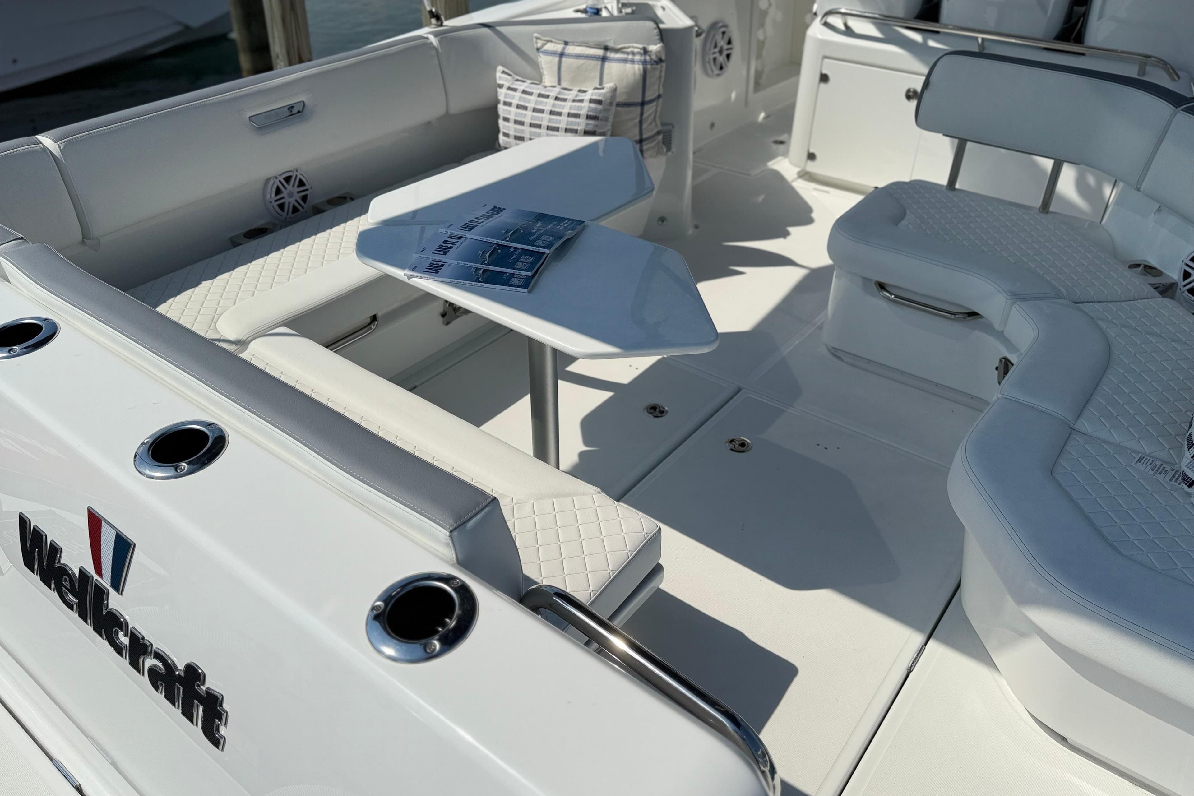 2026 Wellcraft 38 T-Top boat interior with white seating and table, showcasing luxury design.