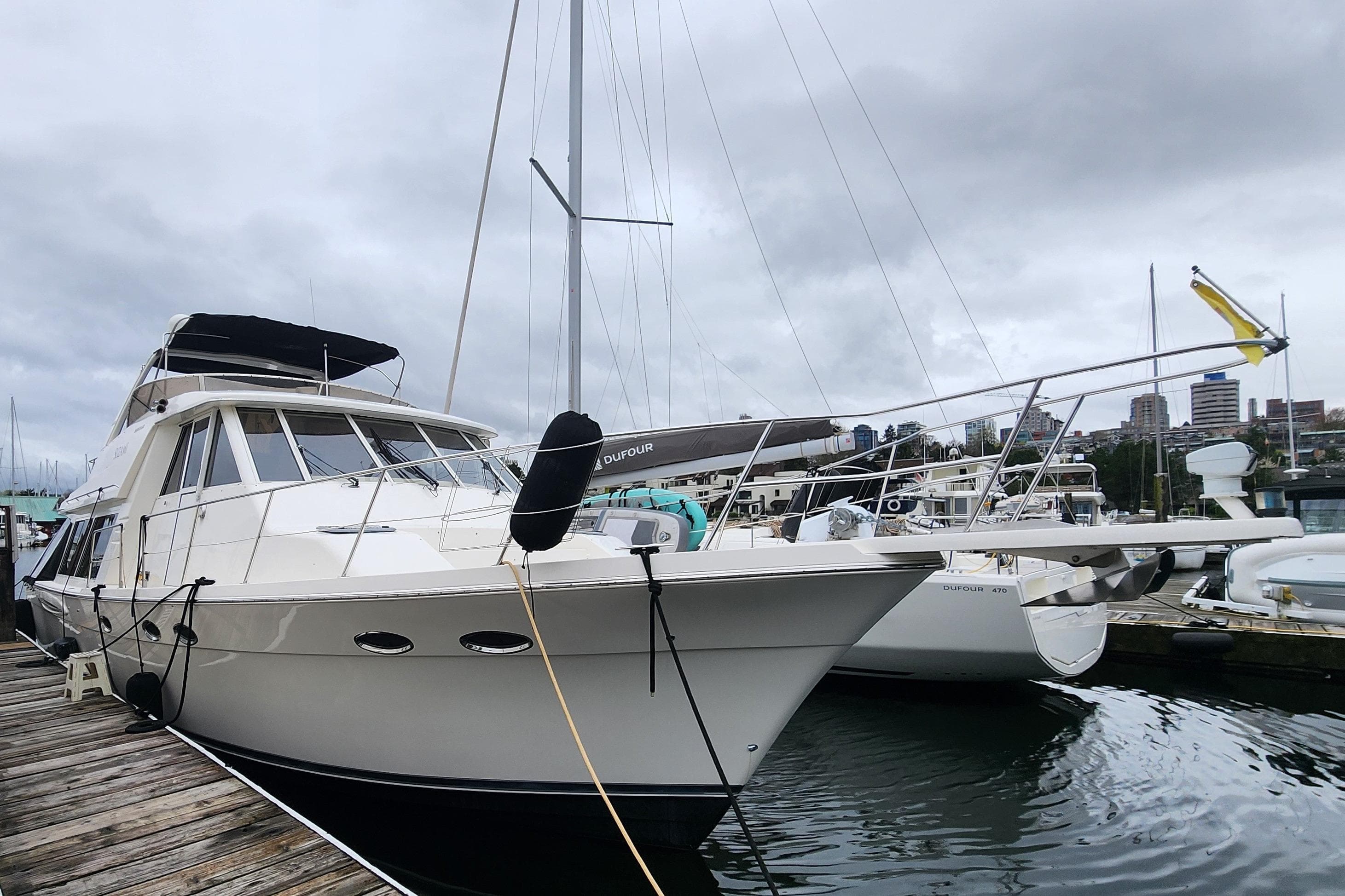 2003 Meridian 490 Pilothouse yacht docked at marina under cloudy skies.