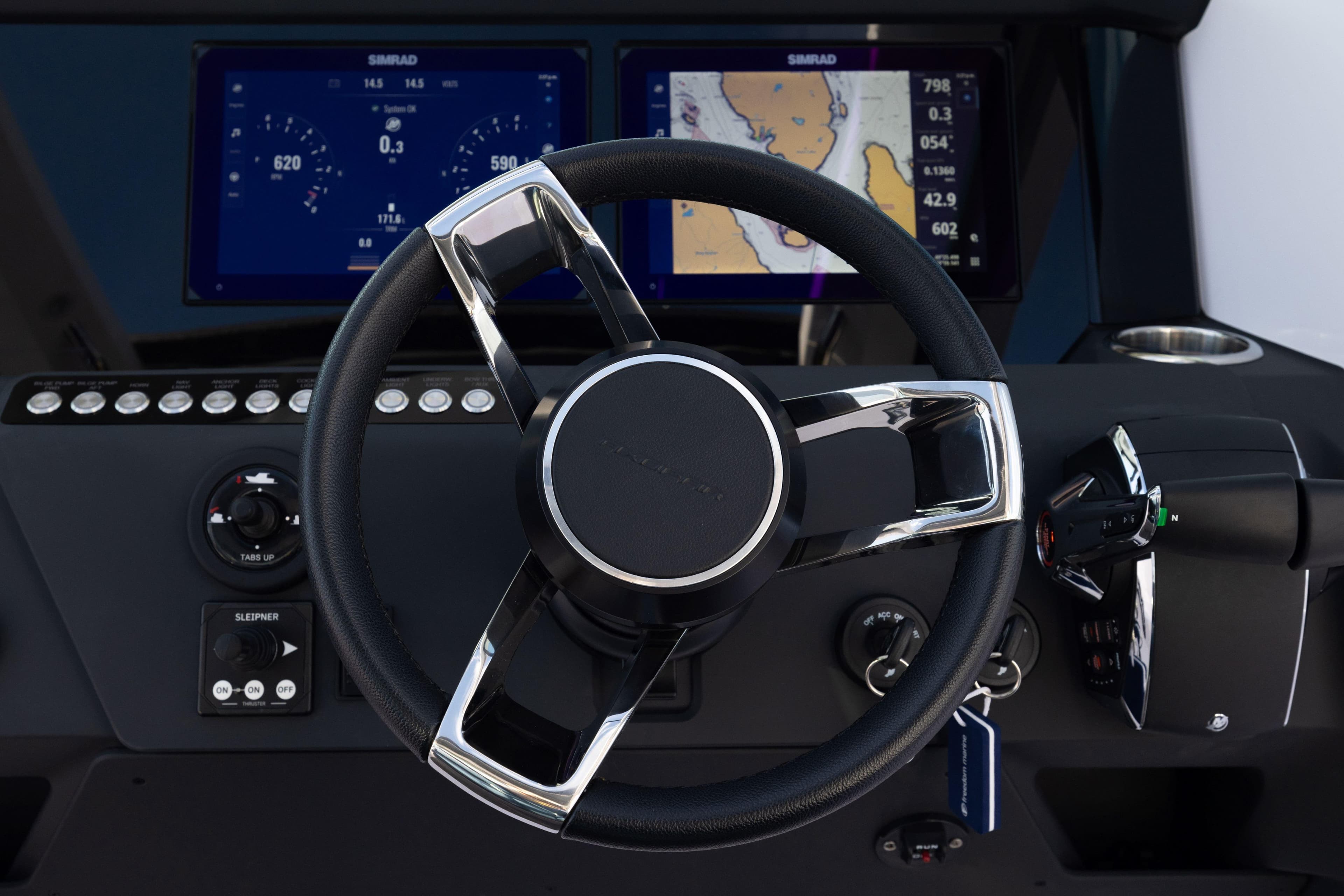 Steering wheel and dashboard of 2026 Axopar 29XC Cross Cabin boat with navigation screens.