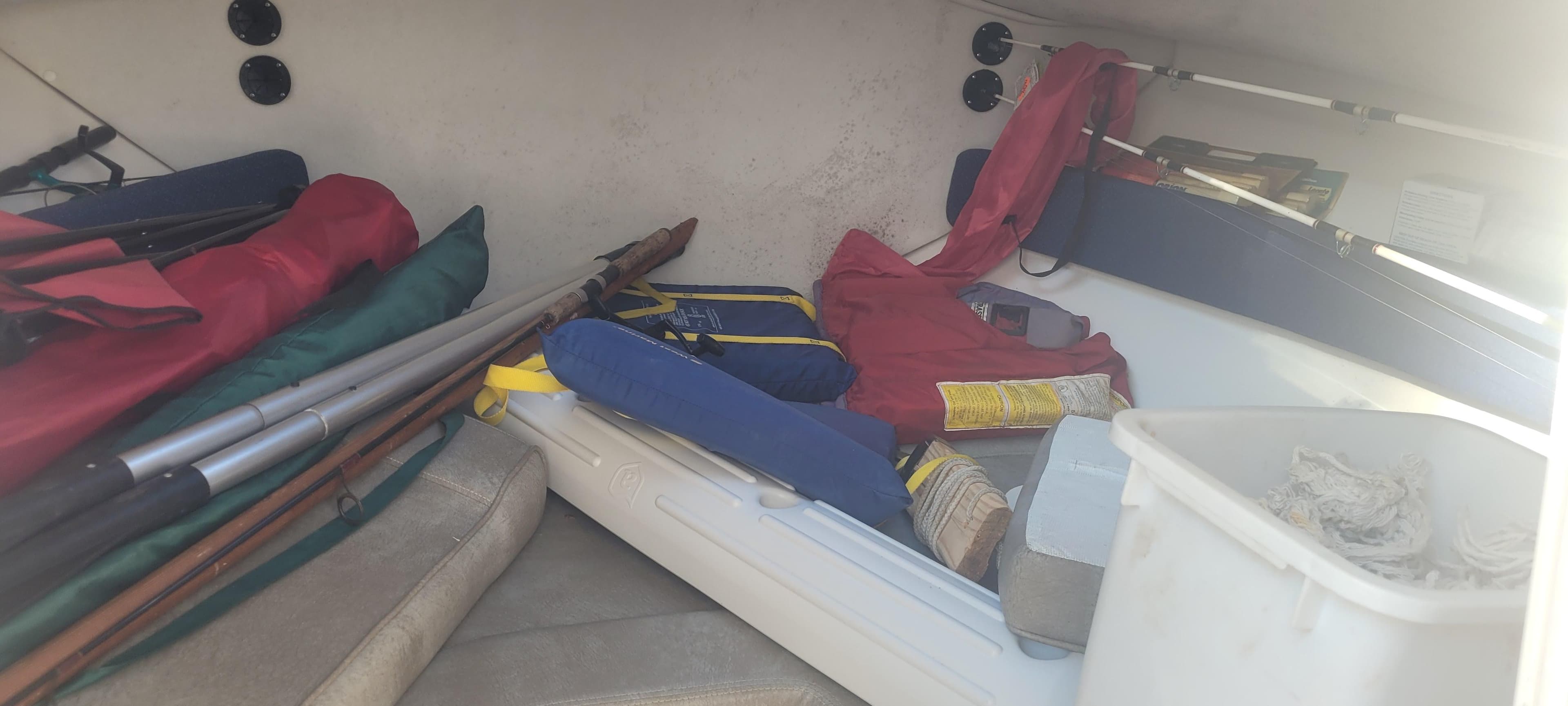 Interior storage of 1999 Boston Whaler 23 Conquest boat with various equipment and supplies.