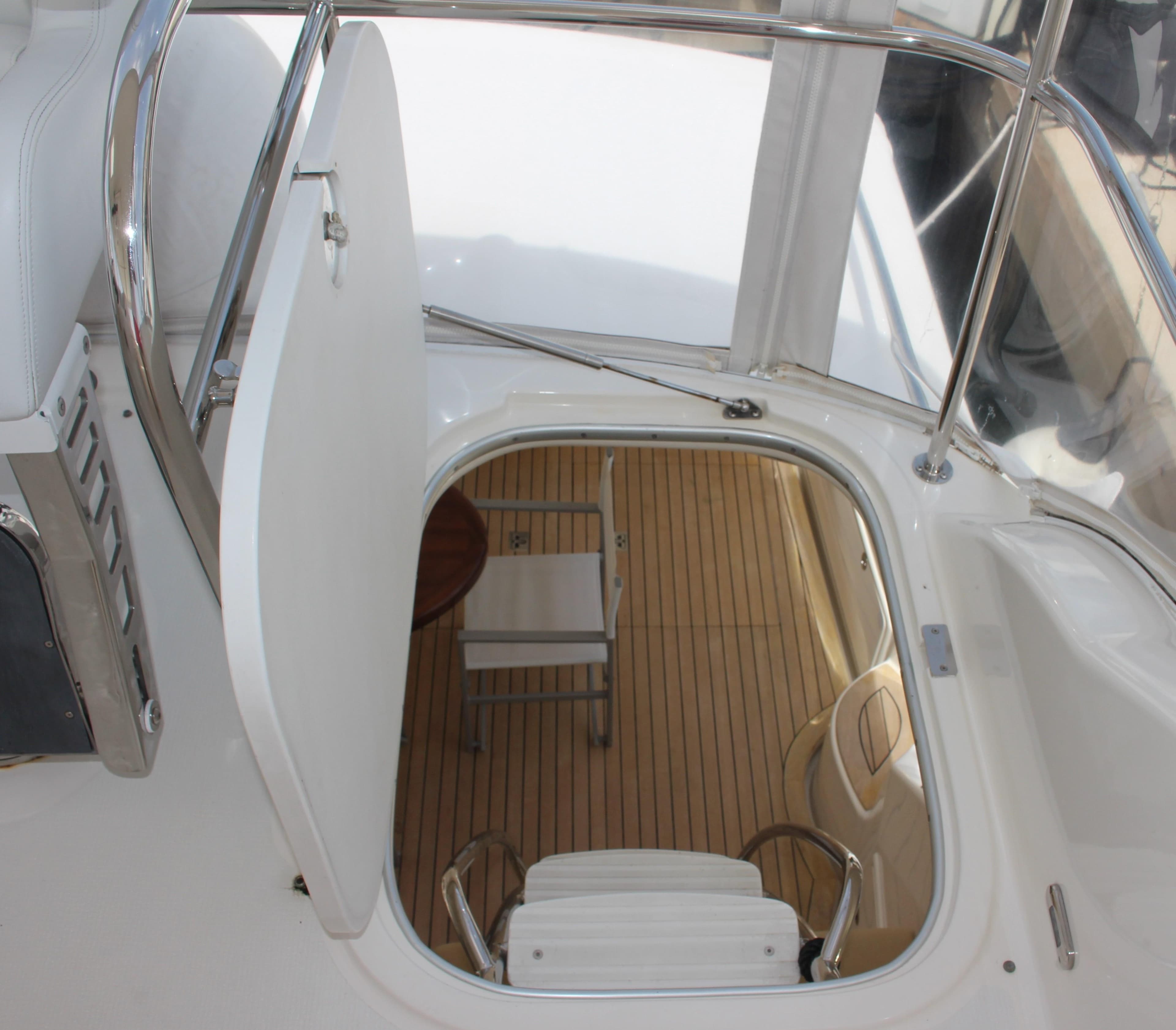 Hatch and stairs leading to the interior of a 2005 Riviera 51 Flybridge yacht.