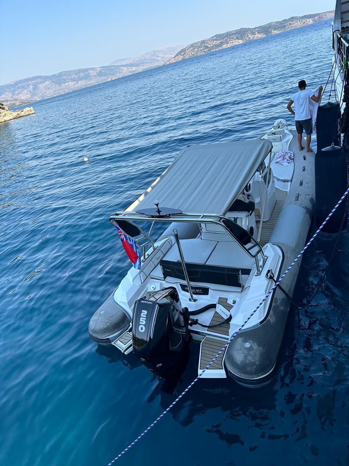 2021 Ranieri Cayman 26 boat moored on clear blue water, scenic coastal background.